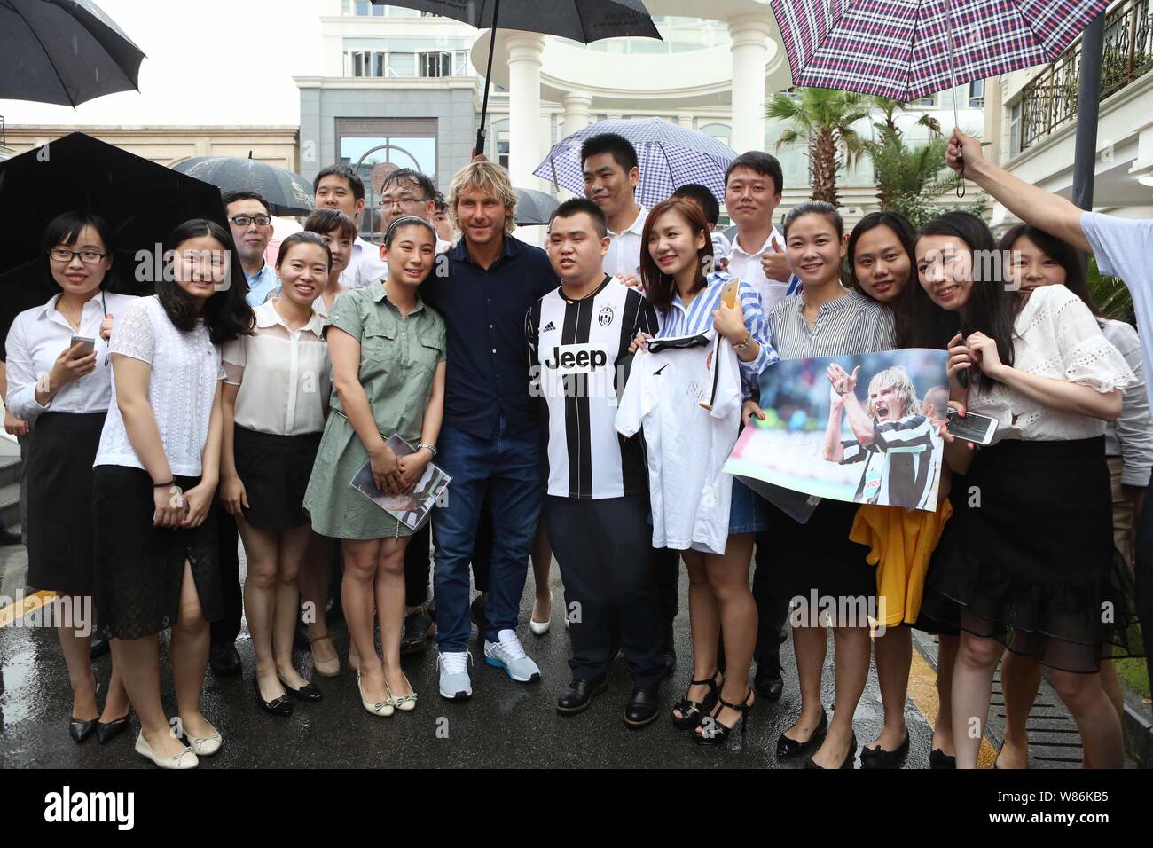 La star de football Tchèque Pavel Nedved, centre, pose avec les fans et les employés comme il arrive au siège de la Chine CEFC Co., Ltd. comme l'image Banque D'Images