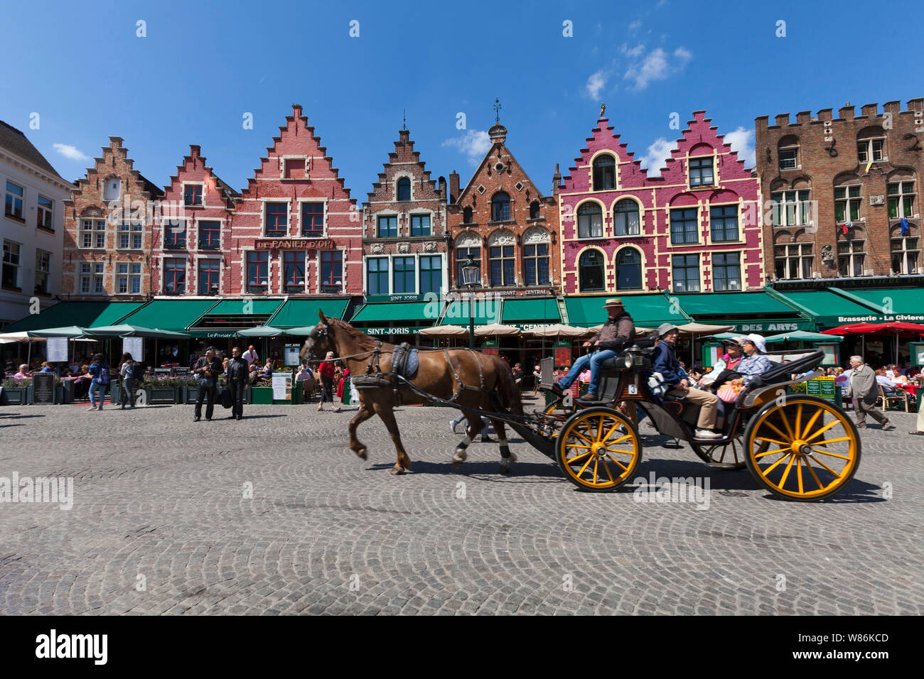 Bruges, Flandre occidentale, Belgique : façade de bâtiments traditionnels flamands dans la place principale Markt (place du marché) des terrasses de café et en calèche. Banque D'Images
