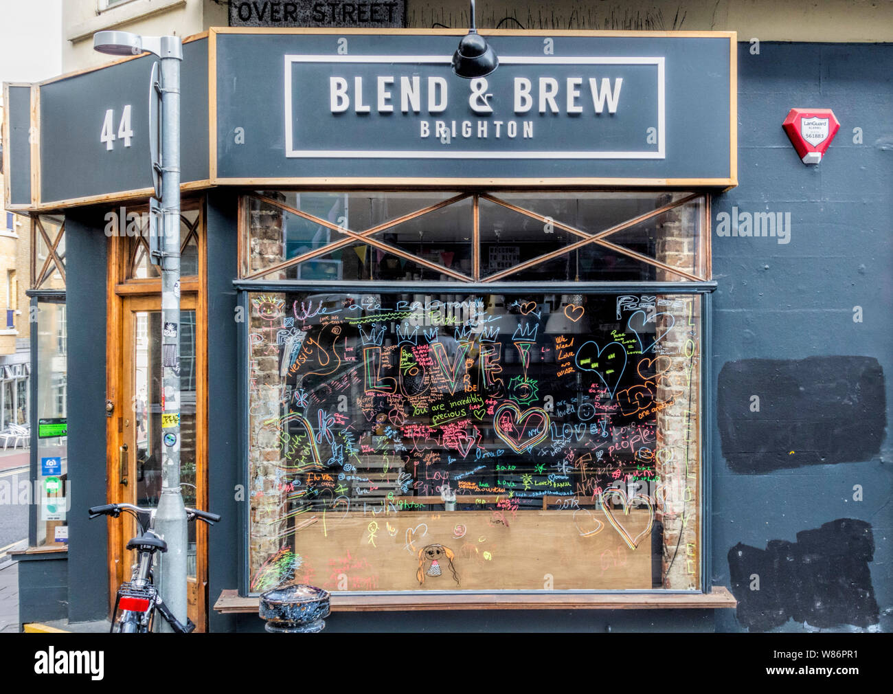 Blend & Brew Coffee shop, plus Street, Brighton East Sussex UK avec fenêtres couvertes de graffiti à l'appui de la fierté LGBT Banque D'Images