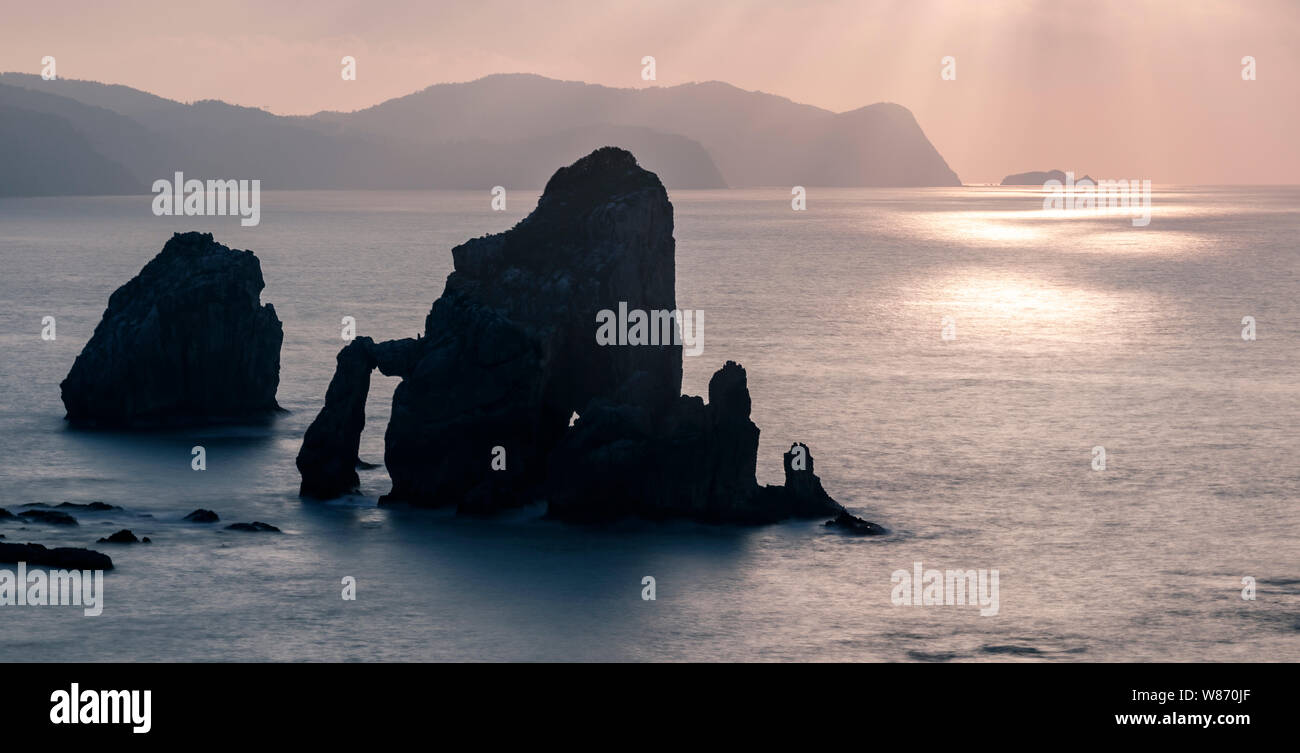 Rochers dans la mer au coucher du soleil Banque D'Images