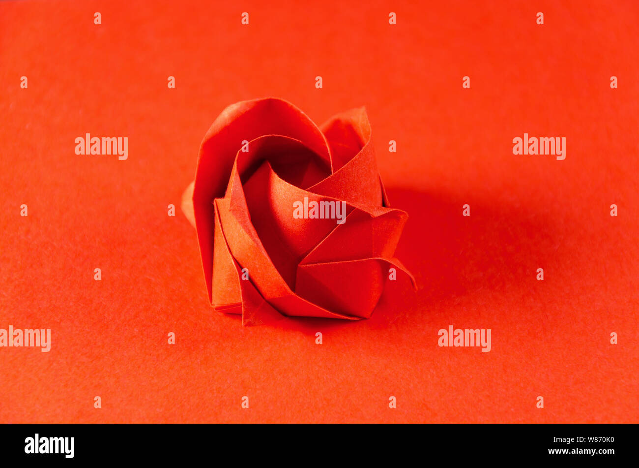 Origami rose rouge sur fond rouge. L'art japonais du pliage de papier.  Feuille de papier carré plat transférés dans une sculpture terminée par le  pliage Photo Stock - Alamy