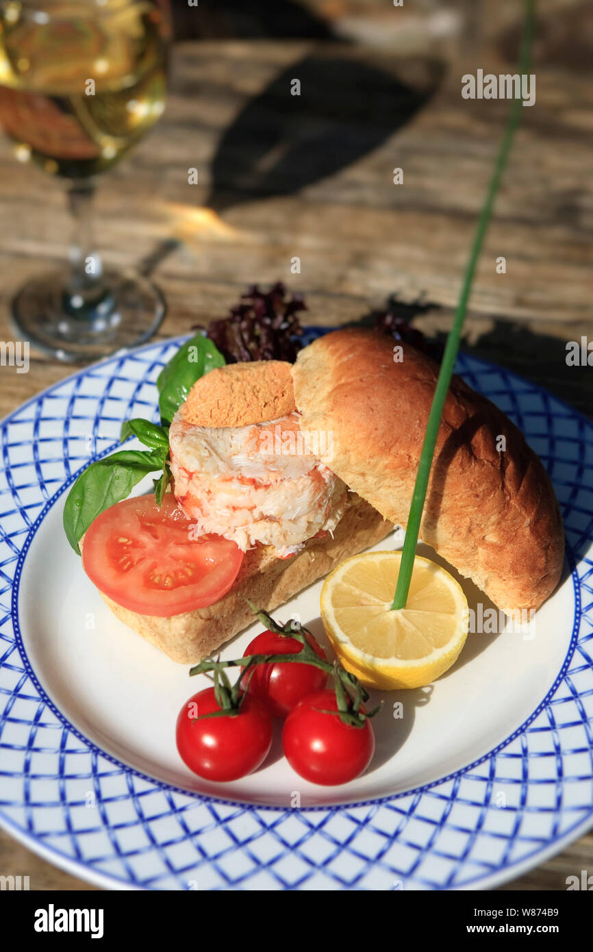 Sandwich au crabe frais avec une salade de tomates et un verre de vin en plein air Banque D'Images