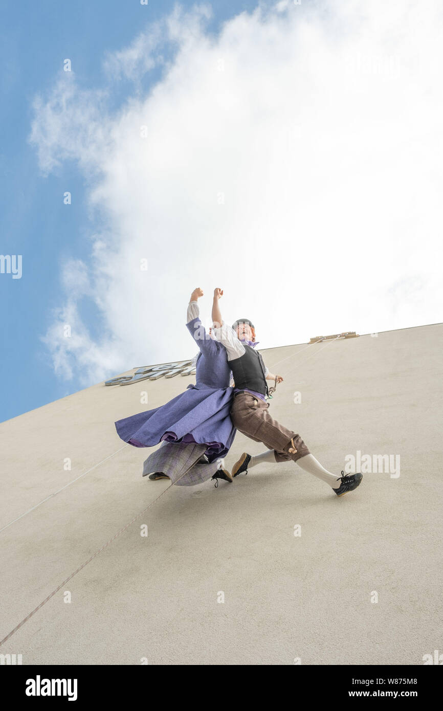 Llandudno Galles UK, jeudi 08 août 2019 Danseurs LISA SPAULL amd ANGHARAD JONES performing 'Wal Werin' , une version ludique d'une danse folklorique traditionnel gallois , effectué verticalement sur le mur de théâtre venue Cymru à Llandudno au Pays de Galles. L'événement fait partie d'une série d'activités de la semaine lomg en collaboration avec la National Eisteddfod de galles à LLanrwst, juste en bas de la vallée de Conwy crédit photo Keith Morris / Alamy Live News Banque D'Images