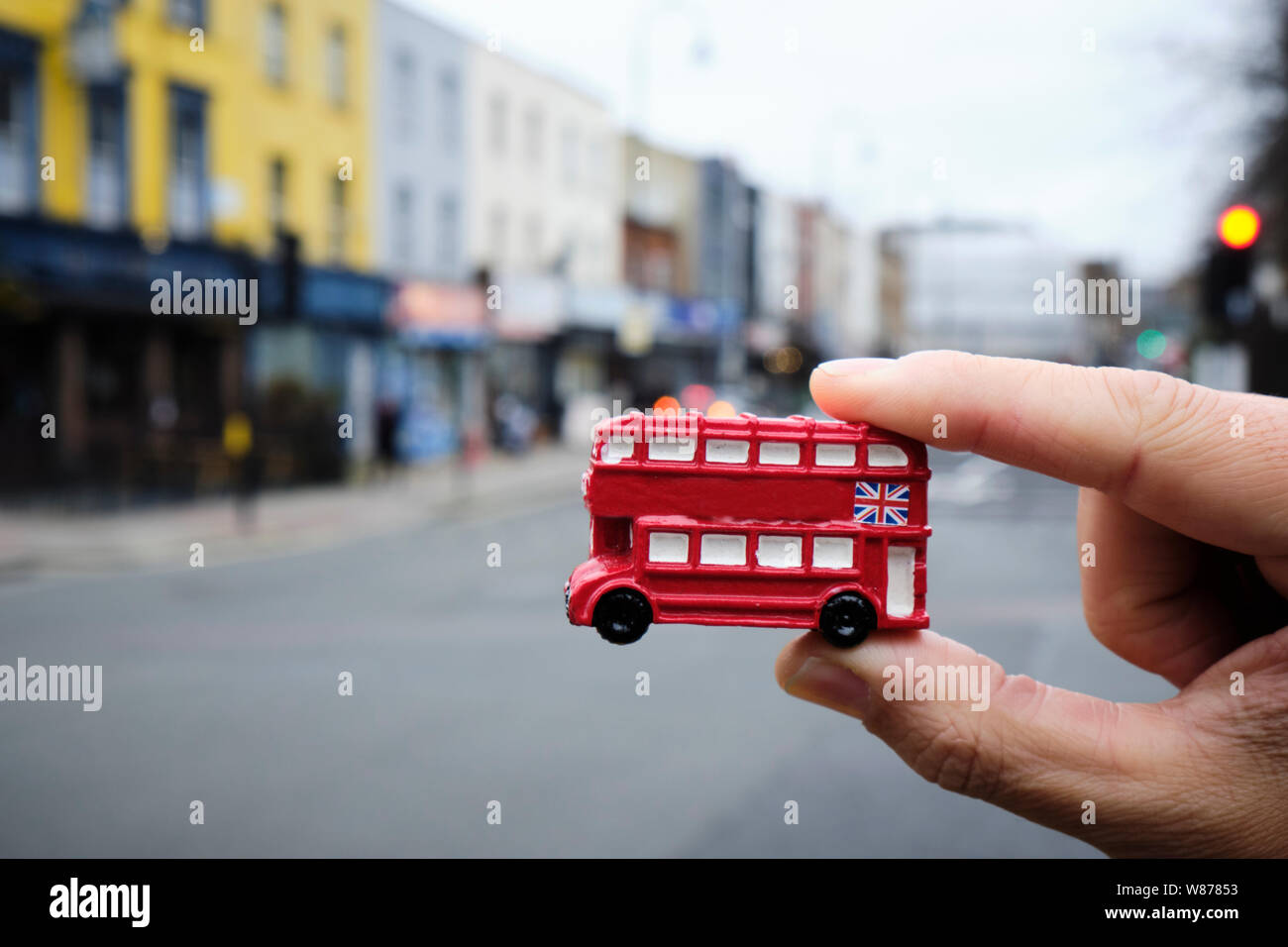 Libre de la main d'un young man holding une miniature d'un bus à impériale rouge, typique de Londres, Royaume-Uni, sur la rue Banque D'Images