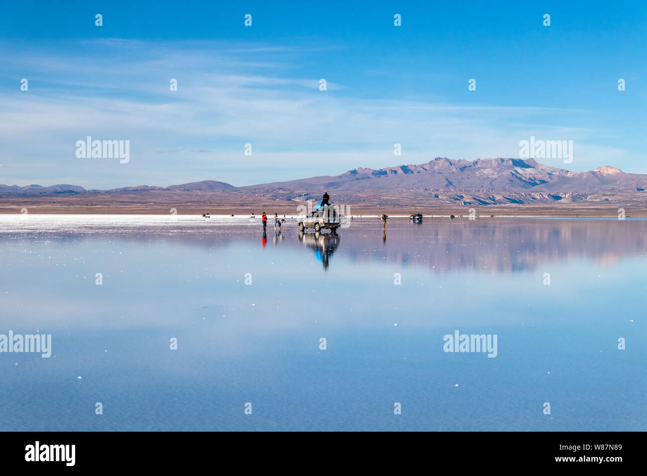 En miroir de l'eau, Salar de Uyuni Uyuni, Bolivie : les touristes se  reflète dans le lac de sel blanc et de profiter d'activités excursion en  jeep dans le désert de sel