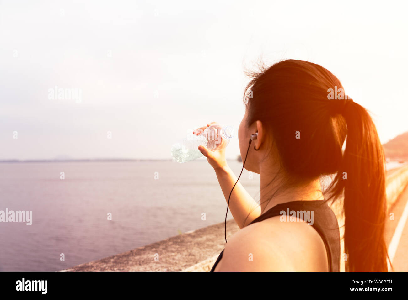 Sport femme debout sur la baie et l'eau potable après l'exécution Banque D'Images