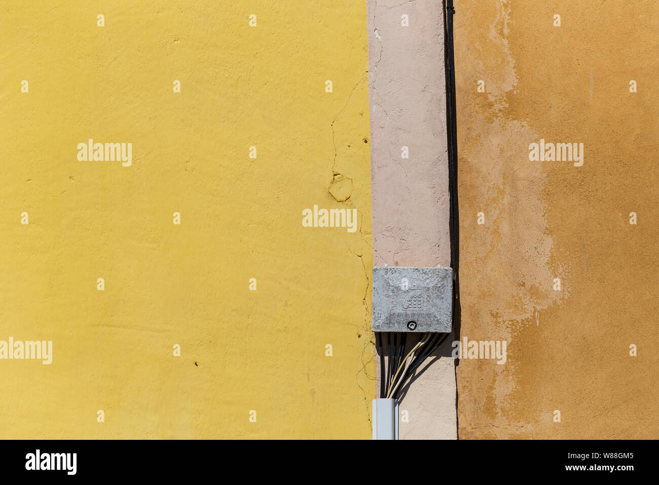 Les câbles téléphoniques sur un mur coloré dans le Roussillon, Provence, France. Banque D'Images