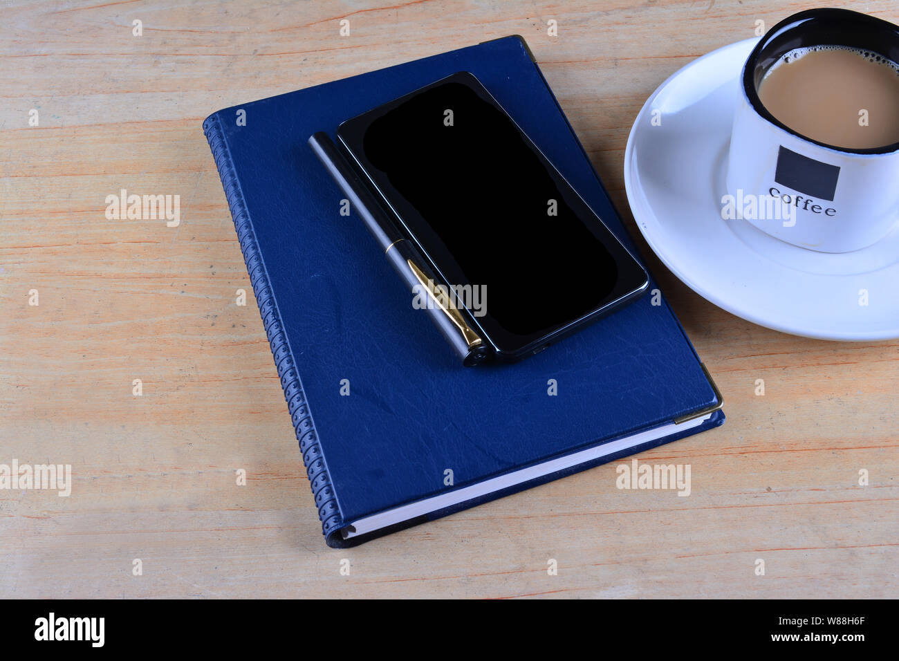 Ordinateur portable blanc, stylo, smartphone et tasse de café sur le bureau Banque D'Images