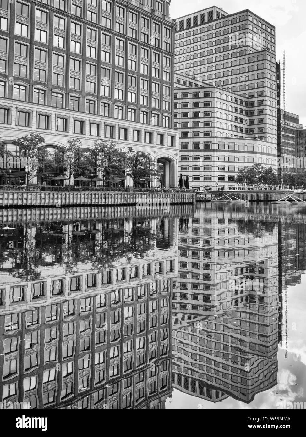 Les immeubles de bureaux avec matrice régulière des fenêtres et des reflets dans l'eau à Londres, West India Quay Banque D'Images