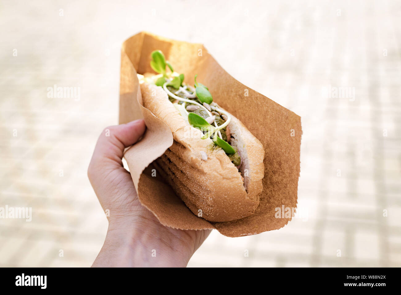 Hot dog végétarien, végétalien avec saucisse de soja à main de femme dans un festival de rue Banque D'Images
