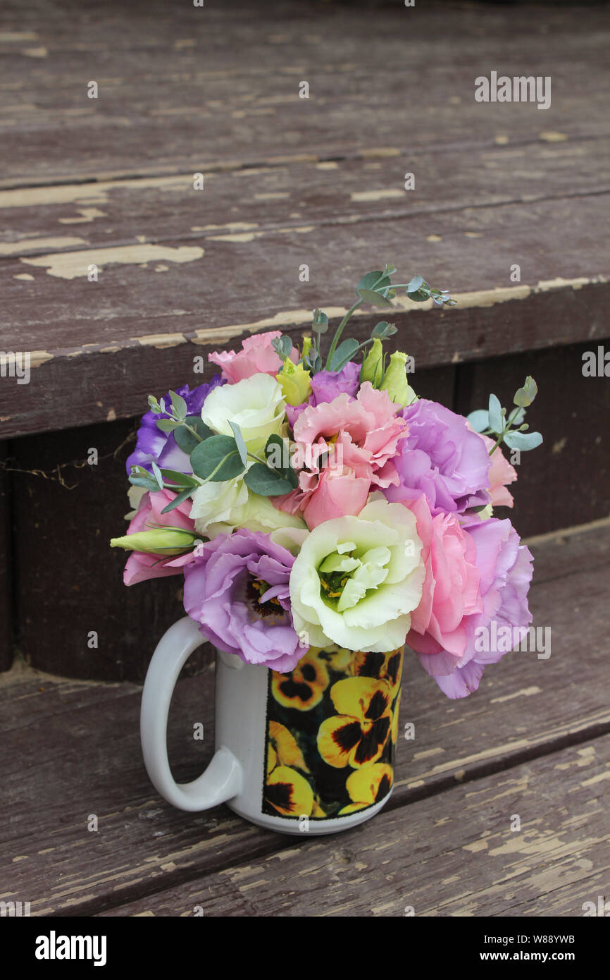 Fleurs Bouquet de lisianthus multicolores dans une tasse avec des pensées Banque D'Images