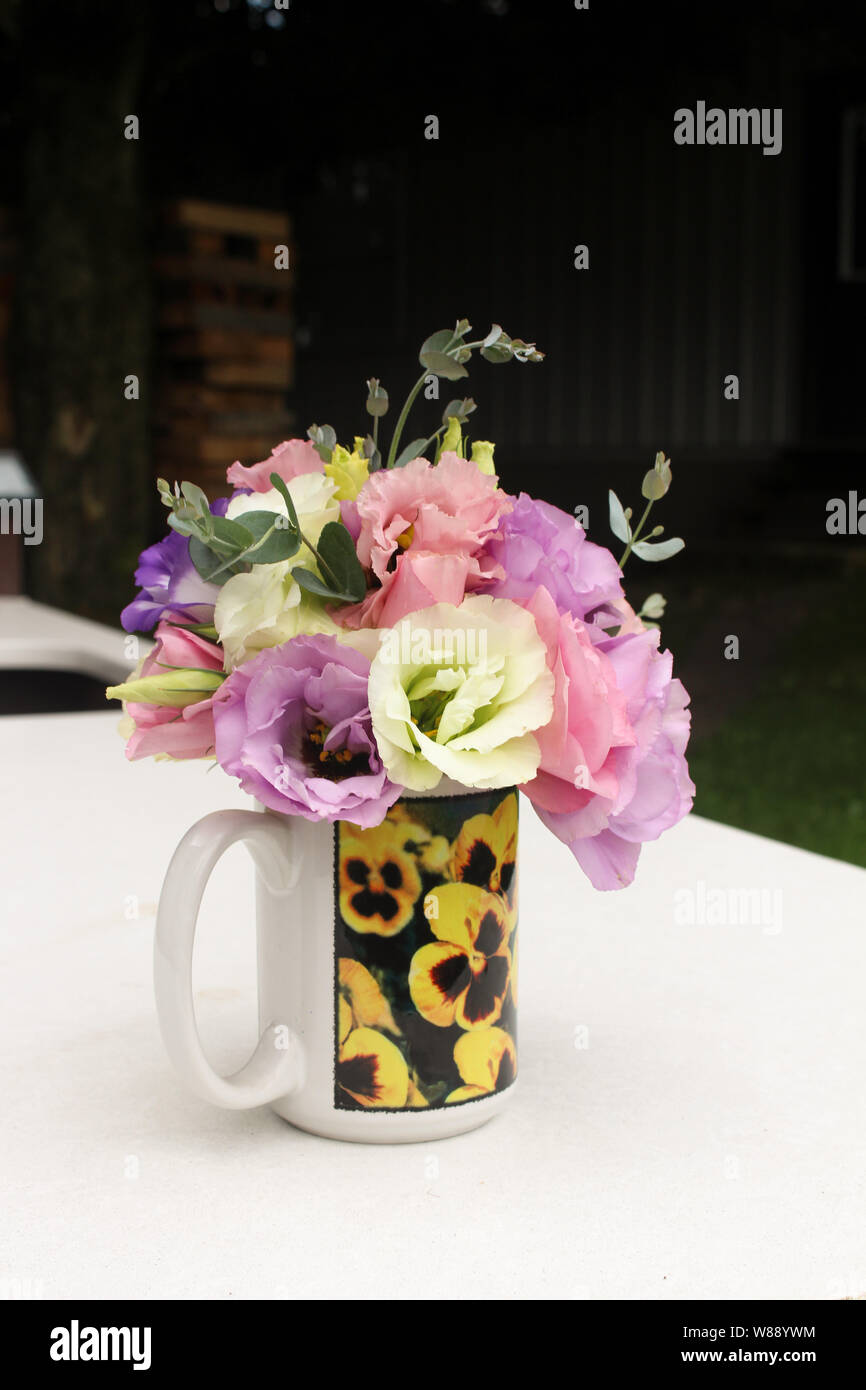 Fleurs Bouquet de lisianthus multicolores dans une tasse avec des pensées Banque D'Images