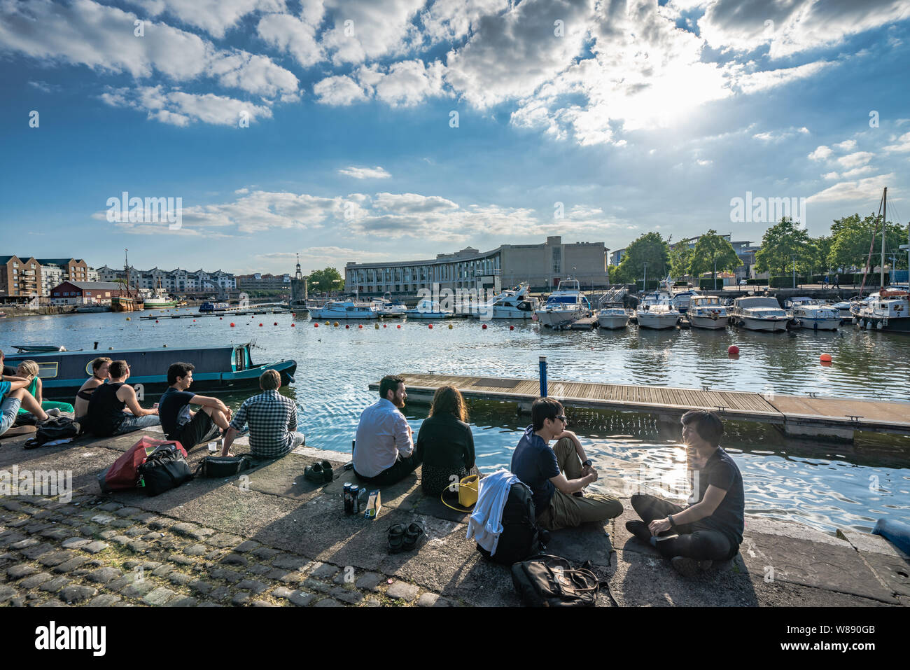 Les gens assis au bord de la rivière de la zone portuaire de Bristol Banque D'Images
