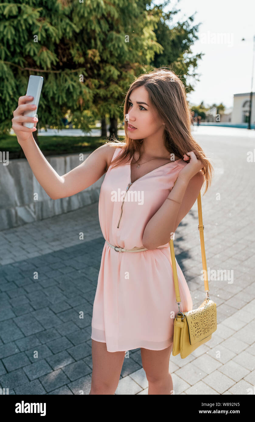 Fille en robe, l'été en ville, se tient dans sa main le téléphone, appel  vidéo, photographie d'elle-même, l'application miroir, chat en ligne,  Internet Réseau social Photo Stock - Alamy
