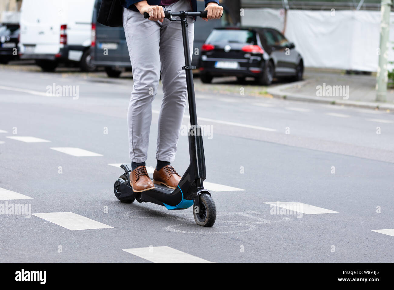 Close-up of a Businessman Riding un Scooter électrique sur City Road Banque D'Images
