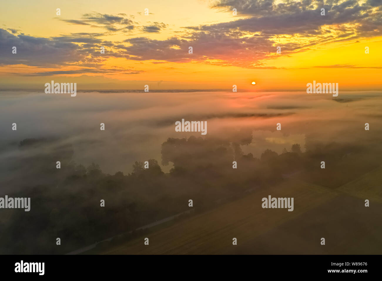 Matin brouillard sur un lac alors que le soleil se lève. Banque D'Images