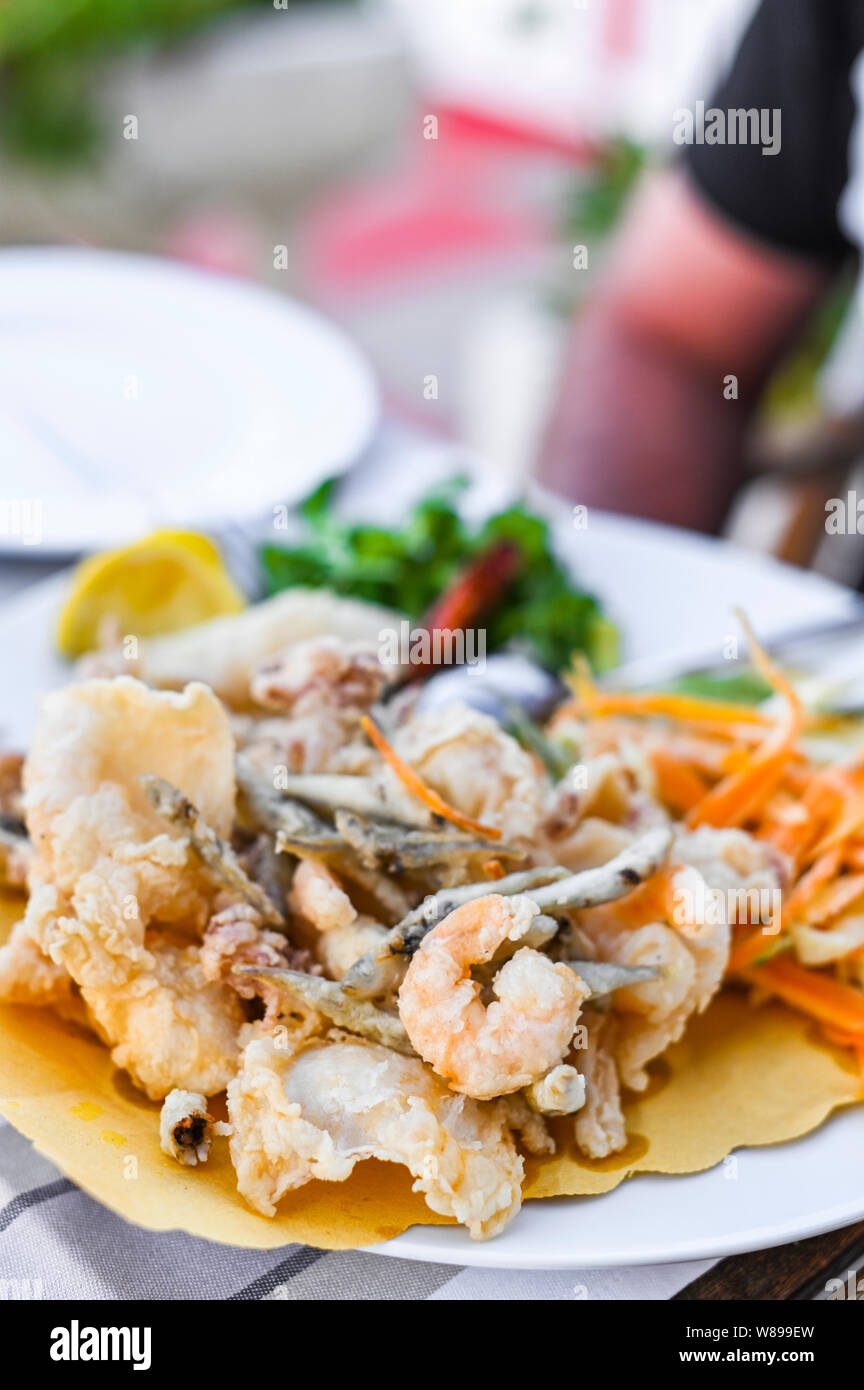 Mélange de fruits de mer frits. Déjeuner de fruits de mer au restaurant. Des plats italiens traditionnels. Les crevettes, les calmars et les petits poissons frits Banque D'Images