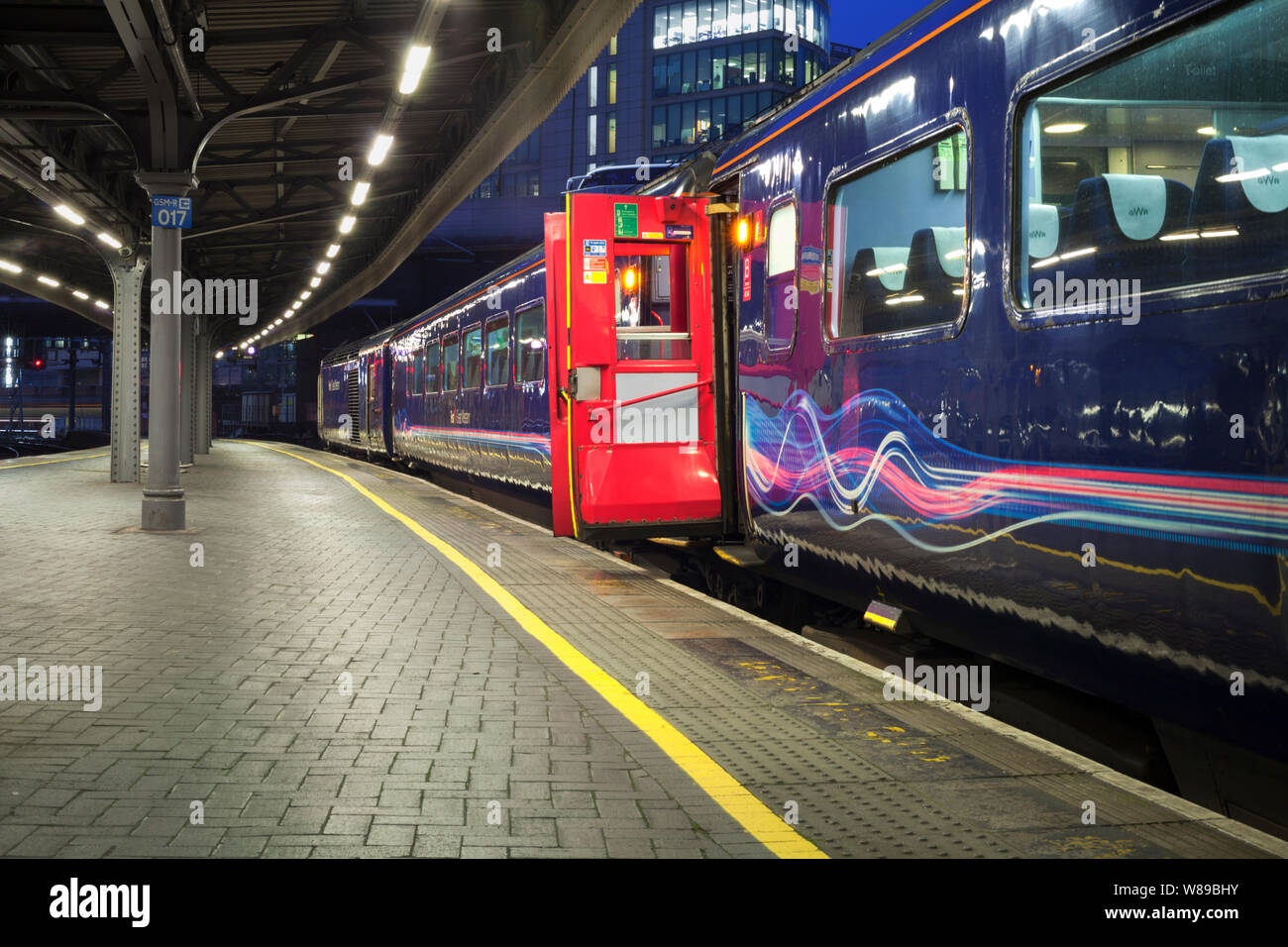 First Great Western train à grande vitesse avec de claquer les portes à la gare de Paddington, l'accomplissement Firstgroup couleurs lignes dynamiques Banque D'Images
