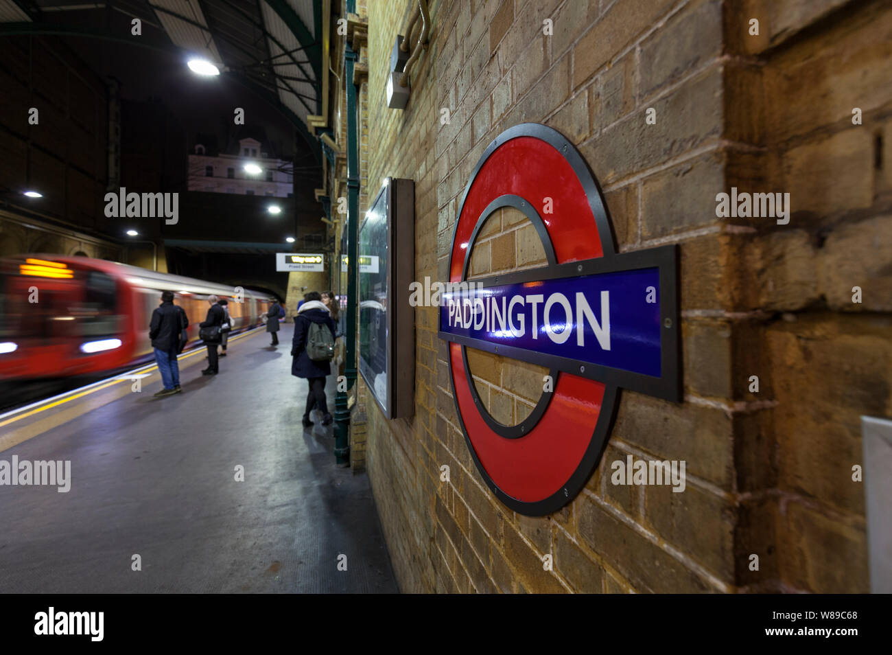 La station de métro de Paddington, district line plate-forme vers l'underground train arrivant avec les passagers en attente Banque D'Images