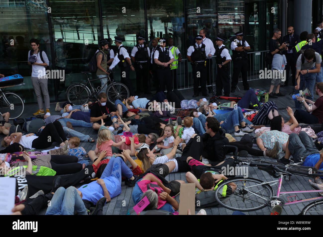 Londres, Royaume-Uni. 18 juillet 2019. Des militants d'Extinction Rébellion ou XR, tenir une mortalité massive dans devant l'Hôtel de Ville, le siège de l'Assemblée de Londres de l'Autorité du Grand Londres, le long de la rivière Thames près de Tower Bridge, exigeant d'action sur une plus juste et plus verte Londres et jurant de retenir un cinquième de leur conseil de Londres taxe qu'ils vont payer en une rébellion fiscale des fonds pour atteindre la neutralité carbone d'ici 2025. Crédit : Joe Keurig / Alamy News Banque D'Images