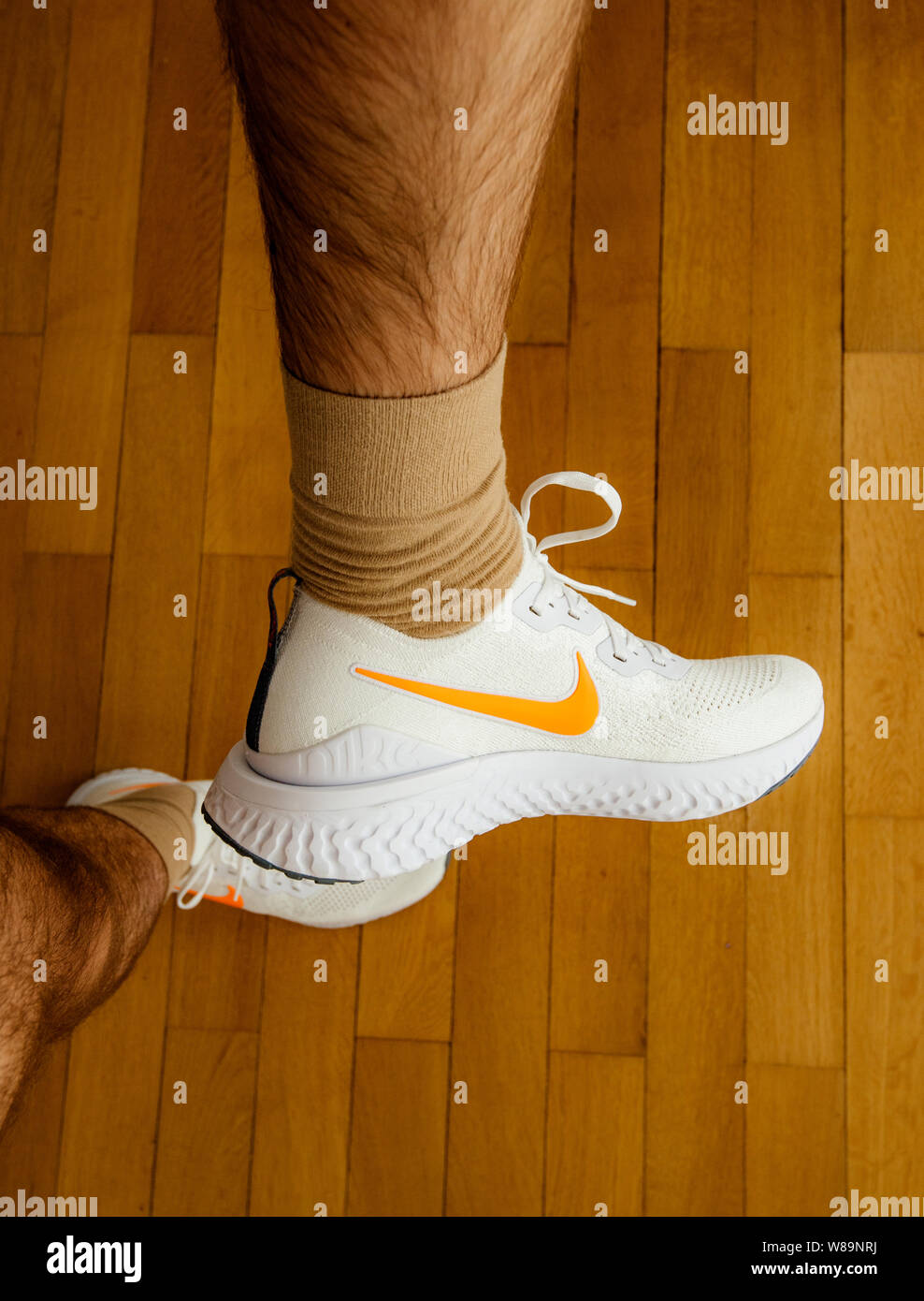 Paris France - 13 juil 2019 : mesure de l'homme nouveau Epic Nike Flyknit  Réagir 2 chaussures de course matériel sur le salon plancher en bois  fabriqués par Nike Sportswear logo blanc