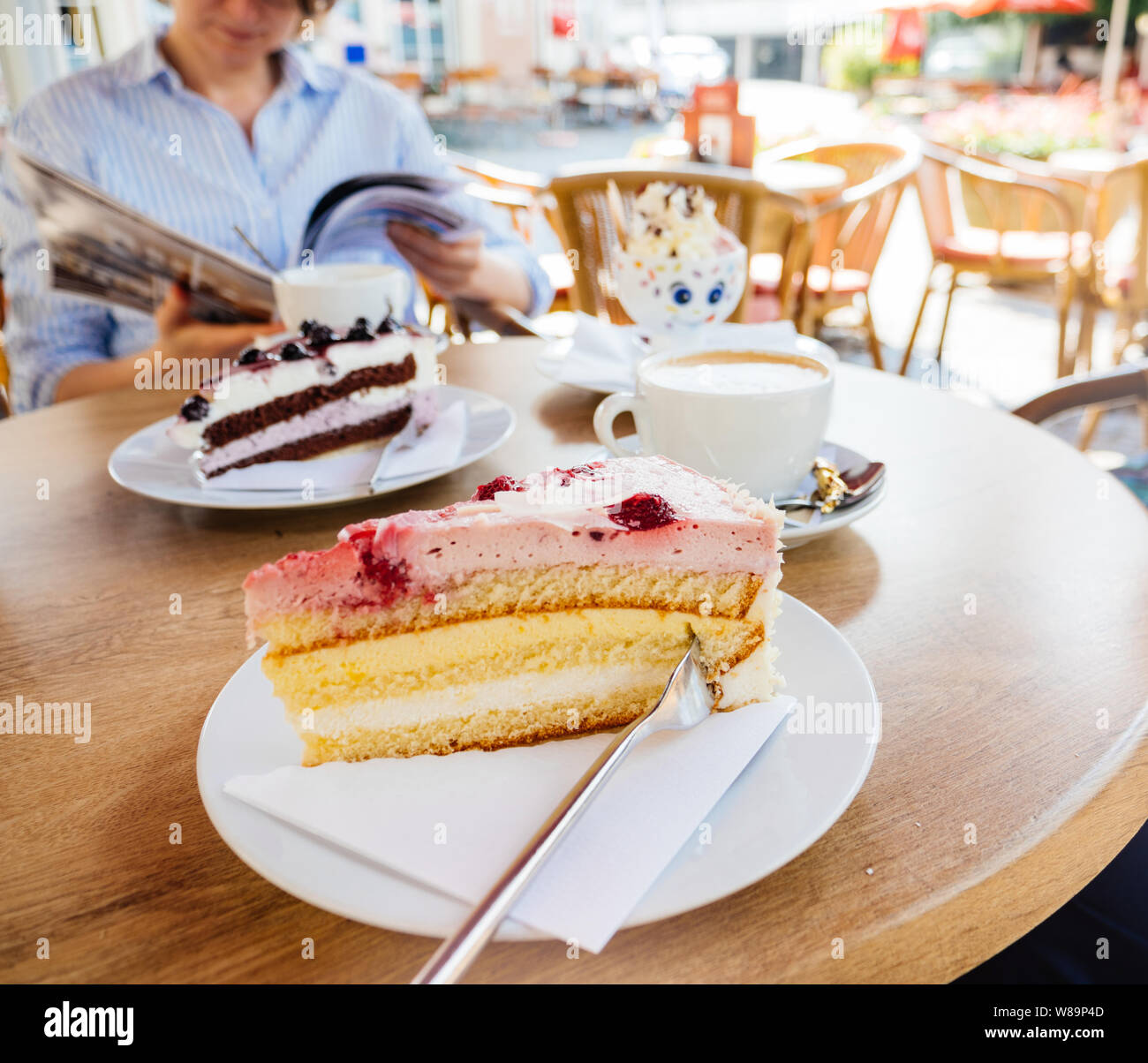 Delicieux Gateau Allemand Avec Fraise Creme Aigre Et De Mangue Avec Elegant Woman Eating Schwarzwald Kirshetarten En Arriere Plan La Lecture D Un Magazine Image Carree Photo Stock Alamy