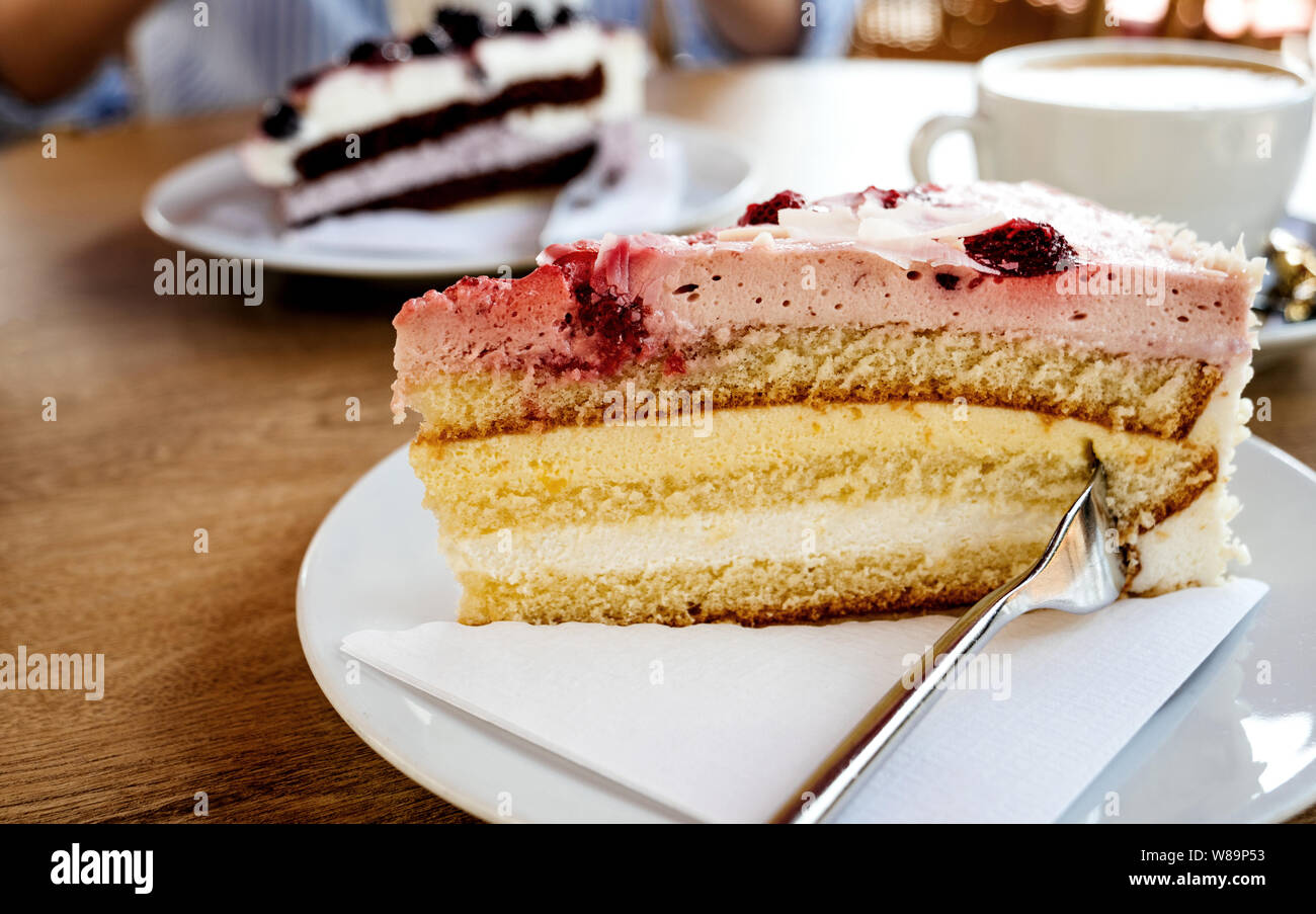 Close Up Image De Delicieux Gateau Allemand Avec Fraise Creme Aigre Et De Mangue Avec Elegant Woman Eating Schwarzwald Kirshetarten En Arriere Plan La Lecture D Un Magazine Photo Stock Alamy