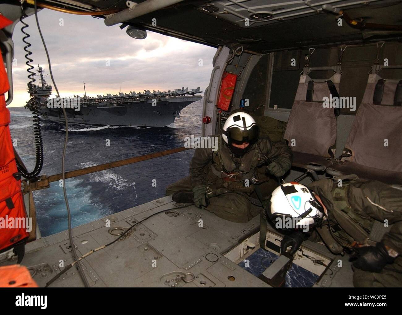 Aircrewmen marine Maître de 2e classe Joseph Broderick et maître de 3e classe Christopher Lovell avoir un œil ci-dessous comme une palette cargo est attaché à l'hameçon de leur hélicoptère MH-60S Knighthawk lors d'une opération de ravitaillement vertical dans l'Océan Atlantique le 6 décembre 2004. La Knighthawk est déployé à bord du USS Seattle (AOE 3) à partir d'hélicoptères de l'Escadron de soutien au combat 8. Le Seattle est un navire de soutien de combat rapide qui fournit un appui logistique à l'USS John F. Kennedy (CV 67) Groupe aéronaval. Broderick est un machiniste de l'aviation de la Marine et l'aviation une Lovell elec Banque D'Images