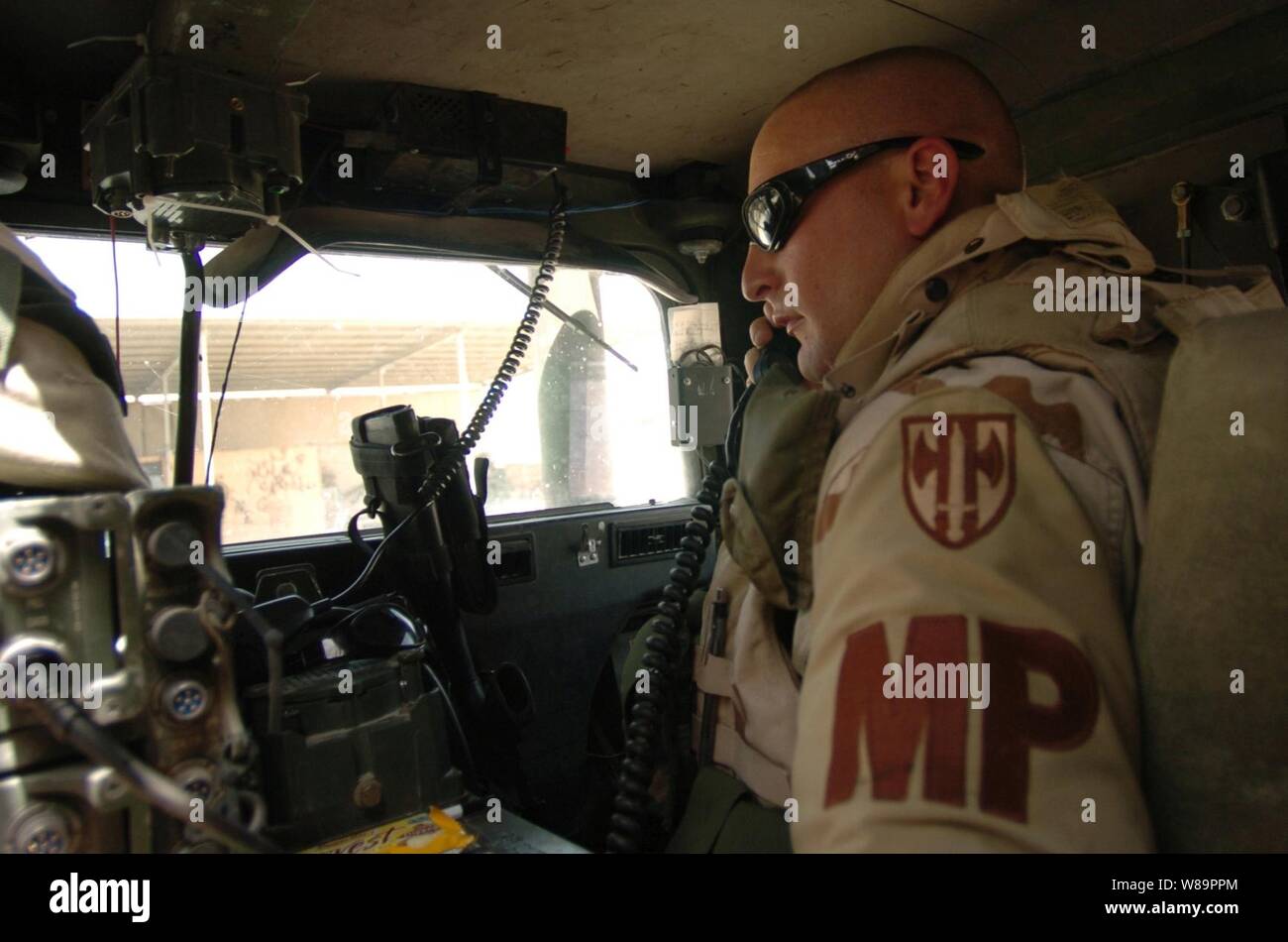 Le personnel de la police militaire de l'Armée de Sgt. Paris Donald radios dans son départ du convoi de munitions avant de livrer l'information au sein de trois postes de police irakienne de Nadjaf, en Irak, le 2 avril 2005. Paris est attaché à la 940e Unité de police militaire et fait partie de la 155e Brigade Combat Team avant déployée au Camp Hôtel au centre de l'Iraq. Banque D'Images