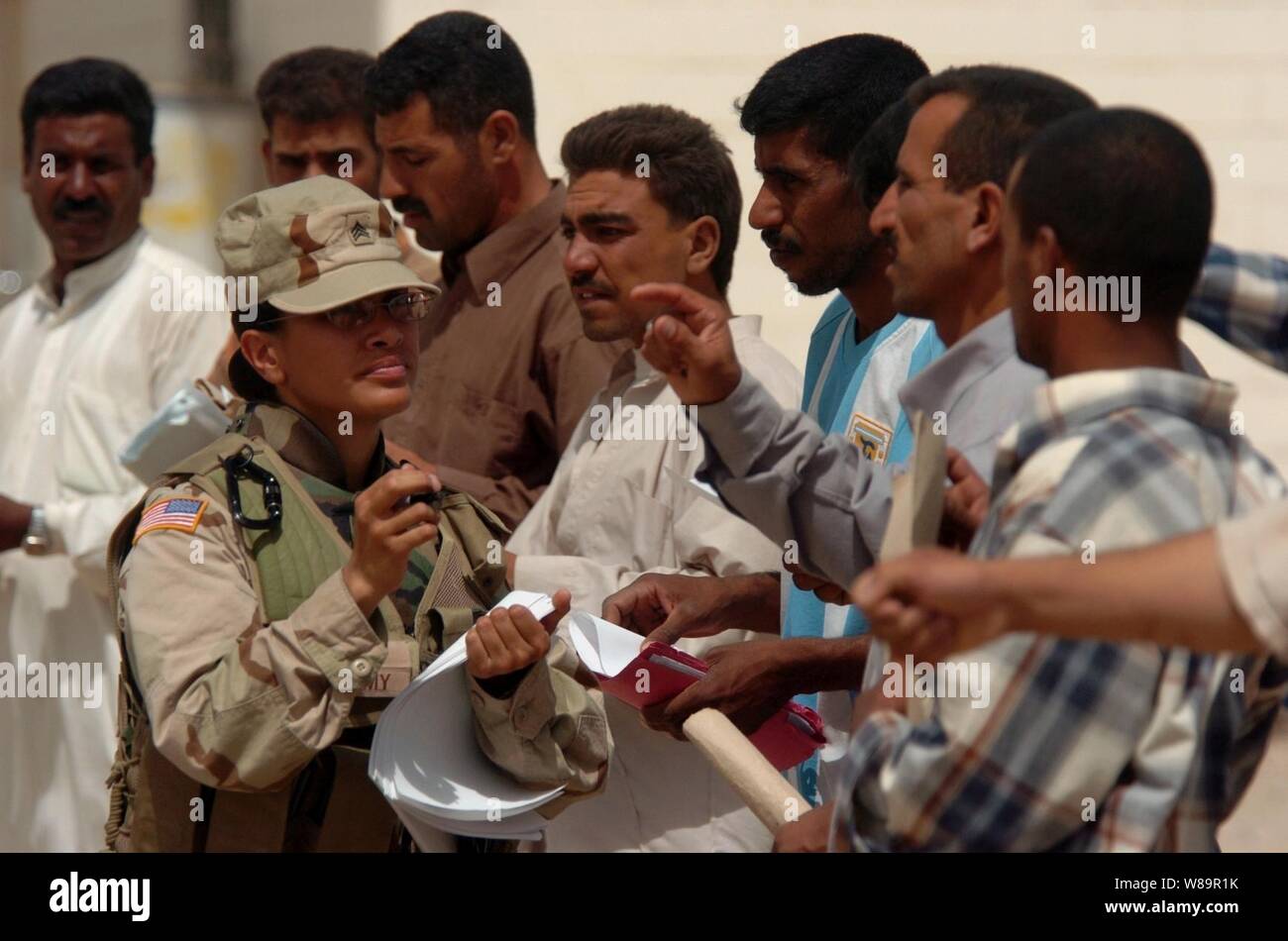 Le sergent de l'armée américaine. Aki ambre aide les hommes irakiens qui se préparent à prendre un test de préparation physique en Ile-de-France, de l'Iraq, au cours de l'examen initial pour la sélection de l'Académie de Formation de la police irakienne le 8 juillet 2005. La projection a lieu à l'armée iraquienne composé et est menée par l'armée irakienne, les forces de police irakiennes, et les soldats américains. Aki est joint à la Compagnie Bravo, 490th bataillon des affaires civiles, 155e Brigade Combat Team. Banque D'Images