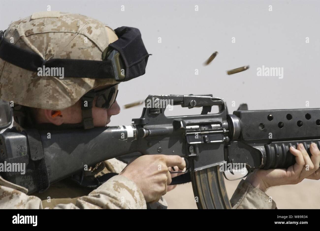 Douilles voler comme un U.S. Marine tire une courte rafale ronde sur son fusil M-16 à la gamme Udari au Koweït le 11 août 2005. La Force de sécurité intérimaire de l'entreprise Marine Corps de la base navale américaine de Bahreïn mène vite soutien la formation des exercices qui ont pour but de tester la capacité de mener des Marines de contrôle des véhicules, les points de contrôle d'entrée et des patrouilles de sécurité mobile. Banque D'Images
