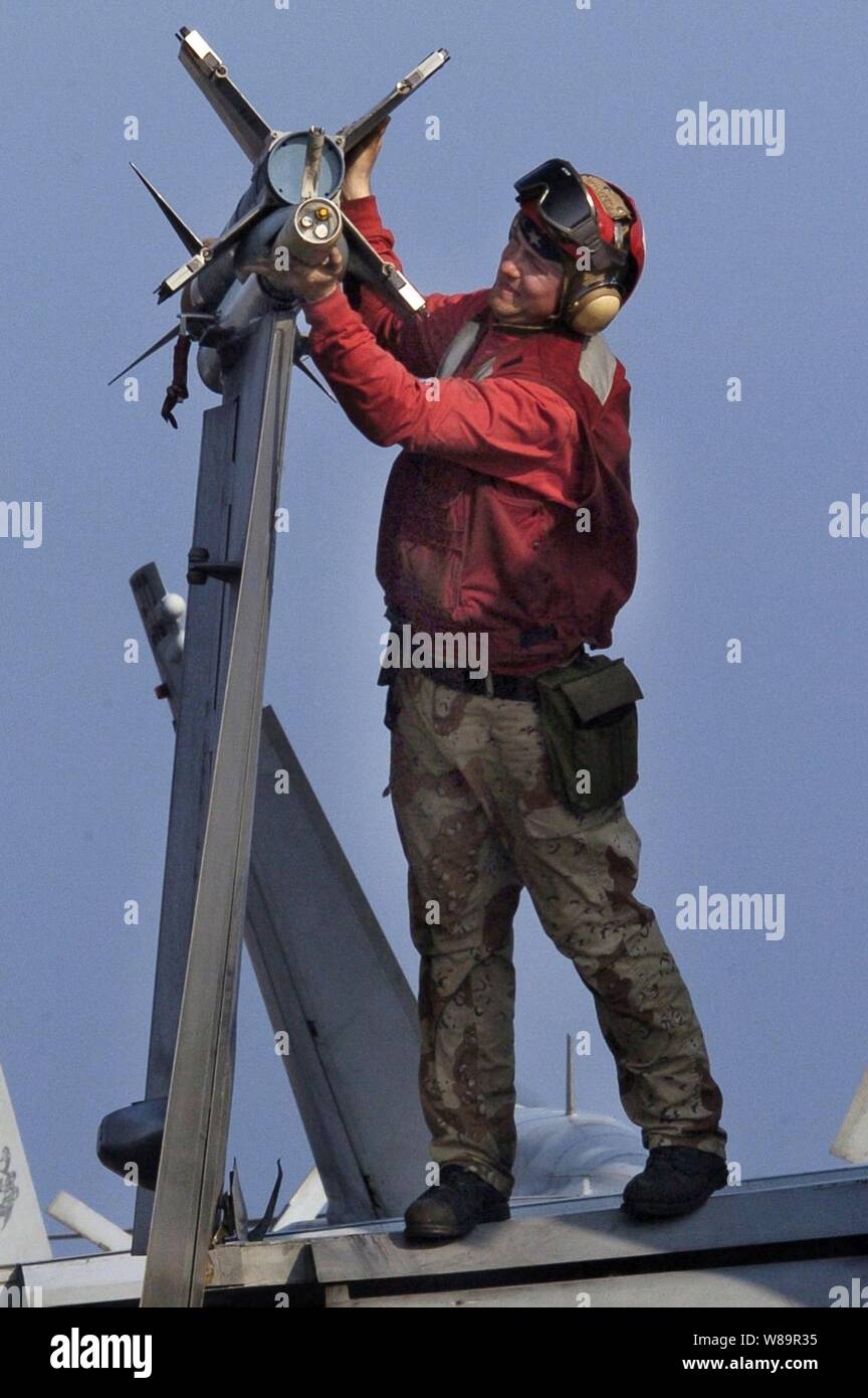 Un ordnanceman l'aviation de la Marine américaine modifie une bouteille d'un rack explosées F/A-18 Hornet sur le pont de l'USS Kitty Hawk (CV 63) comme le navire opère dans l'océan Pacifique sur 10 Août, 2005. Le porte-avions USS Kitty Hawk et le groupe d'assaut amphibie USS Boxer (DG 4) participent à la troisième édition annuelle de l'air commun et d'un exercice en mer 2005 avec l'US Air Force et le Corps des marines dans l'ouest de l'océan Pacifique. L'exercice se concentre sur la gestion intégrée de la formation commune compétence dans la détection, la localisation, le suivi et l'engagement de parts à mer, dans les airs ou sur terre. Banque D'Images