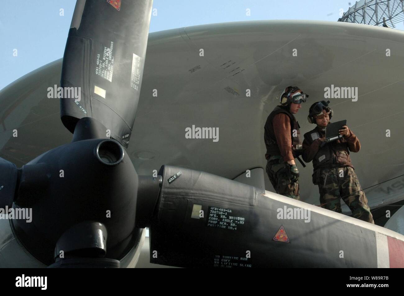 Le Capitaine aviateur avion Nathaniel riche (à droite) et d'un membre de Ricardo Sawh banc sous l'abri du radar rotodome aussi riche indique à son stagiaire Sawh comment effectuer une inspection quotidienne sur un E-2C Hawkeye sur le pont de l'USS Kitty Hawk (CV 63) le 7 novembre 2005. Le Hawkeye est affecté à l'Escadron aéroporté de détection lointaine de l'opérateur 115. Banque D'Images