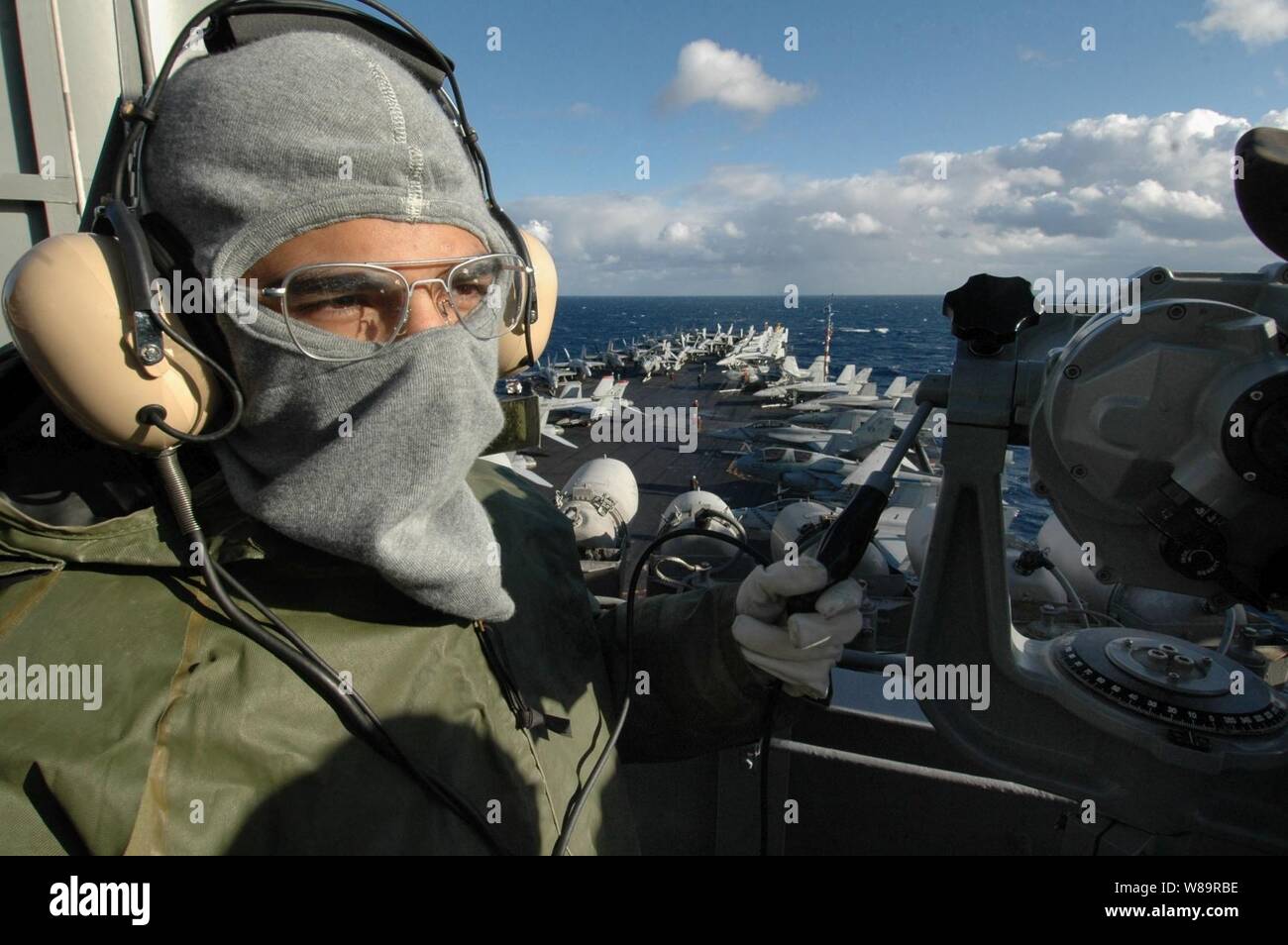 Le Maître de 2e classe de la marine Sonexay est Phommalinh lookout watch sur le signal pont du porte-avions USS Kitty Hawk (CV 63) au cours d'un exercice général quarts le 6 décembre 2005. Le Kitty Hawk est le groupe opérant dans la mer de Chine du Sud à partir de son port d'attache de Yokosuka, Japon. Phommalinh est un quartier-maître de la Marine. Banque D'Images