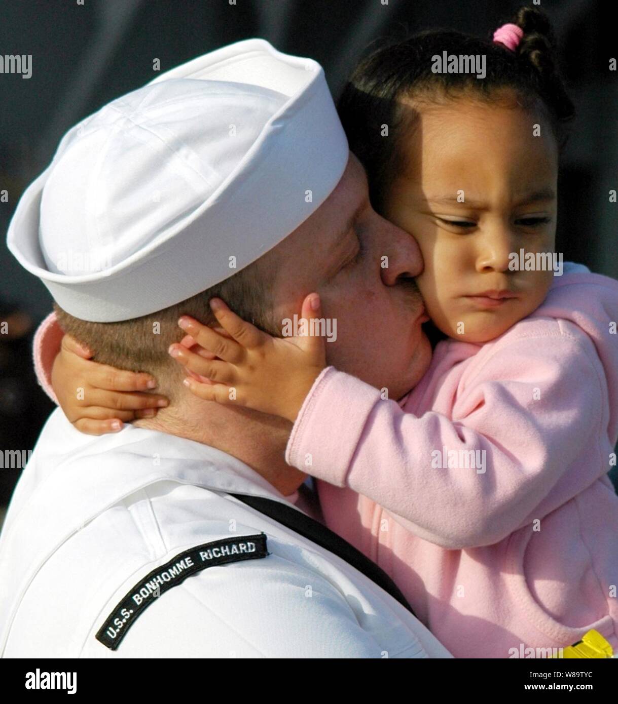 Un marin américain embrasse sa fille au revoir à la base navale de San Diego, Californie, le 10 avril 2007, avant l'embarquement sur le navire d'assaut amphibie USS Bonhomme Richard (DG 6) pour un déploiement de six mois à l'appui d'opérations de sécurité maritime. Banque D'Images