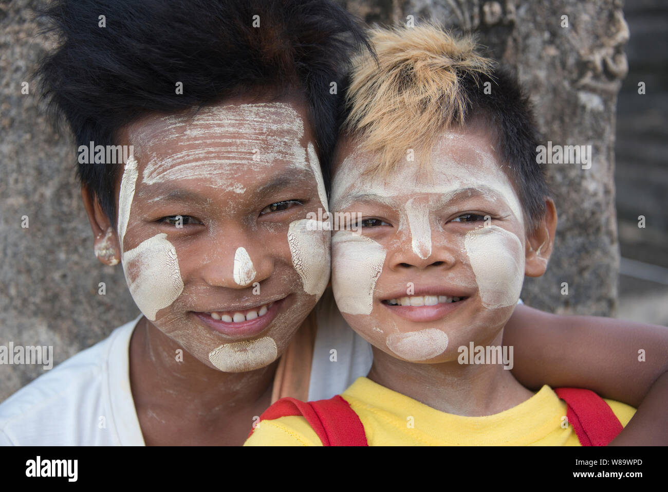 Deux heureux garçons birmans Headshot avec le traditionnel Thanaka un miroir sur lequel est un cosmétique blanche coller à Bagan Myanmar souriant à la caméra. Banque D'Images