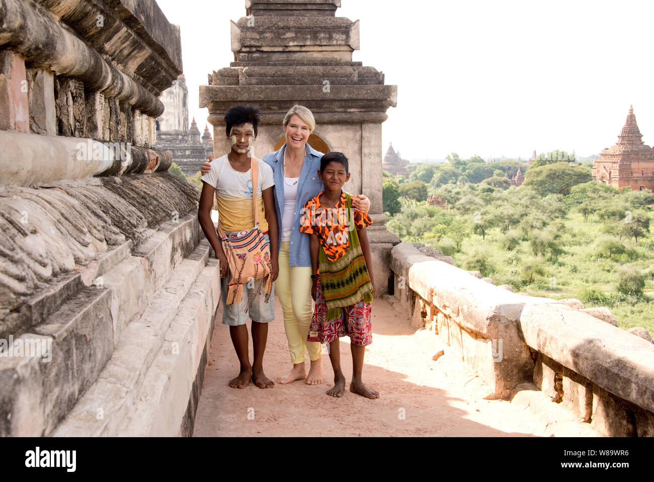 Une Happy Female Tourist et deux garçons birmans souriant à la caméra dans le Temple Thatbyinnyu à Bagan Myanmar portant Thanaka Femme Maquillage libéré. Banque D'Images