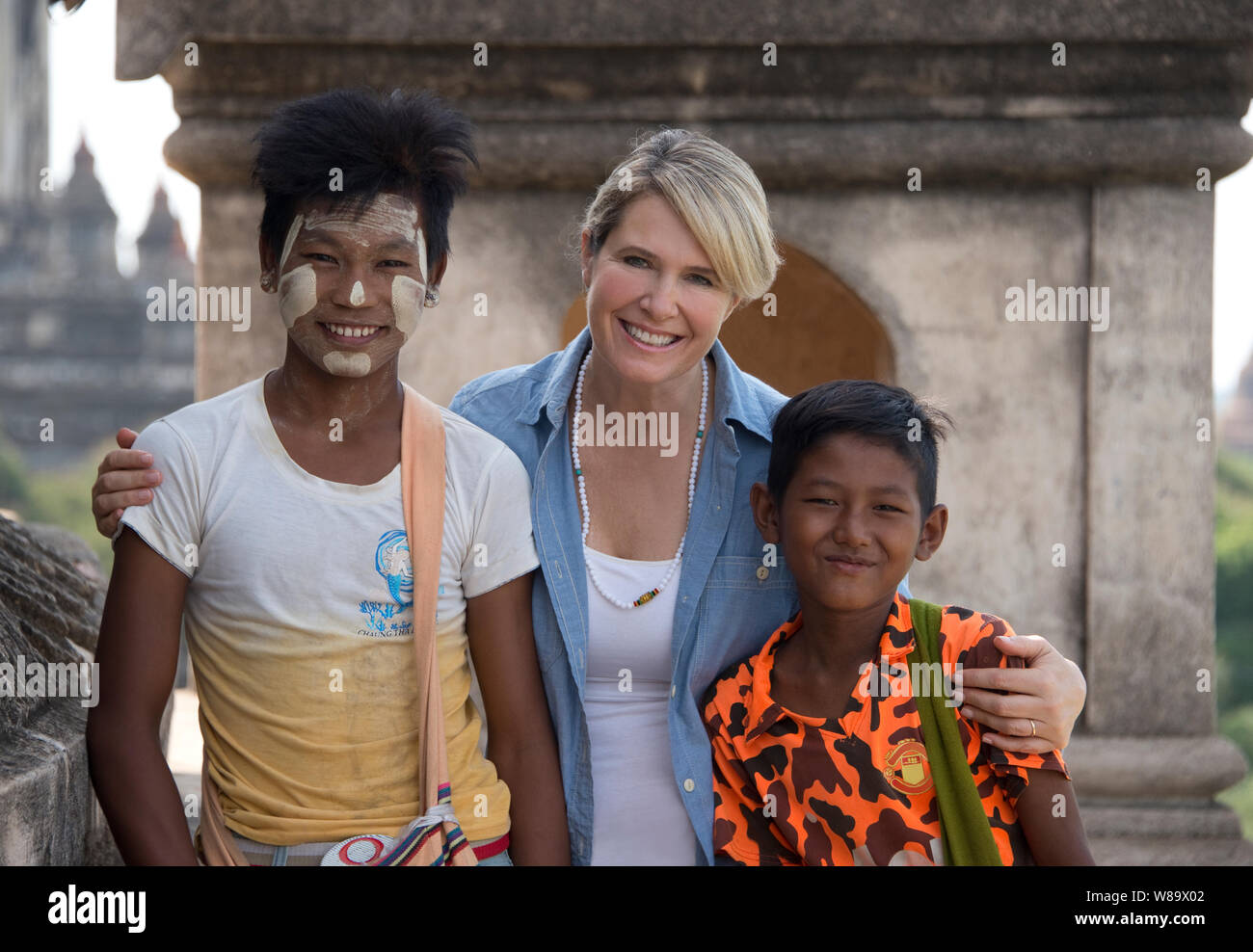Une Happy Female Tourist et deux garçons birmans l'un avec le traditionnel Thanaka un miroir sur lequel est un cosmétique blanche coller et touristique est libéré. Banque D'Images