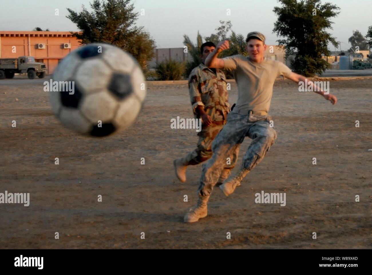 Circuit de l'armée américaine. Casey de la Wailes 1er Escadron, 10e Régiment de cavalerie, 2e Brigade Combat Team, 4e Division d'infanterie, efface la balle pendant un match de football avec des soldats iraquiens à Mahawil, l'Iraq, le 14 décembre 2008. Banque D'Images