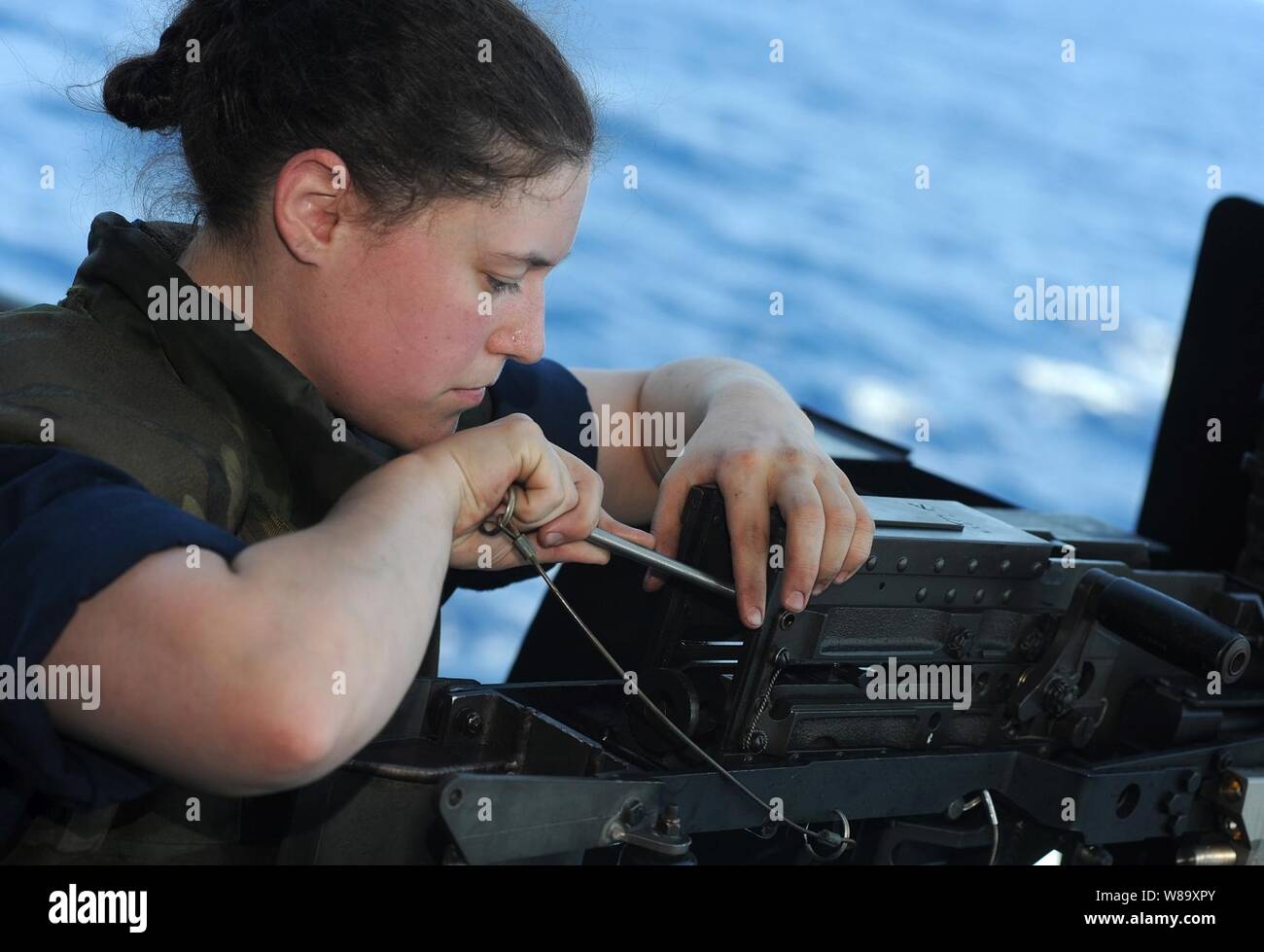 La Marine américaine, le Maître de 3e classe Nicole Blair à réparer un fichier .coincé mitrailleuse de calibre 50 au cours d'un exercice de formation à la sécurité à bord du porte-avions USS Harry S. Truman (CVN 75) en cours dans l'Océan Atlantique du 8 aout 2009. Le navire effectue des qualifications de l'opérateur. Banque D'Images