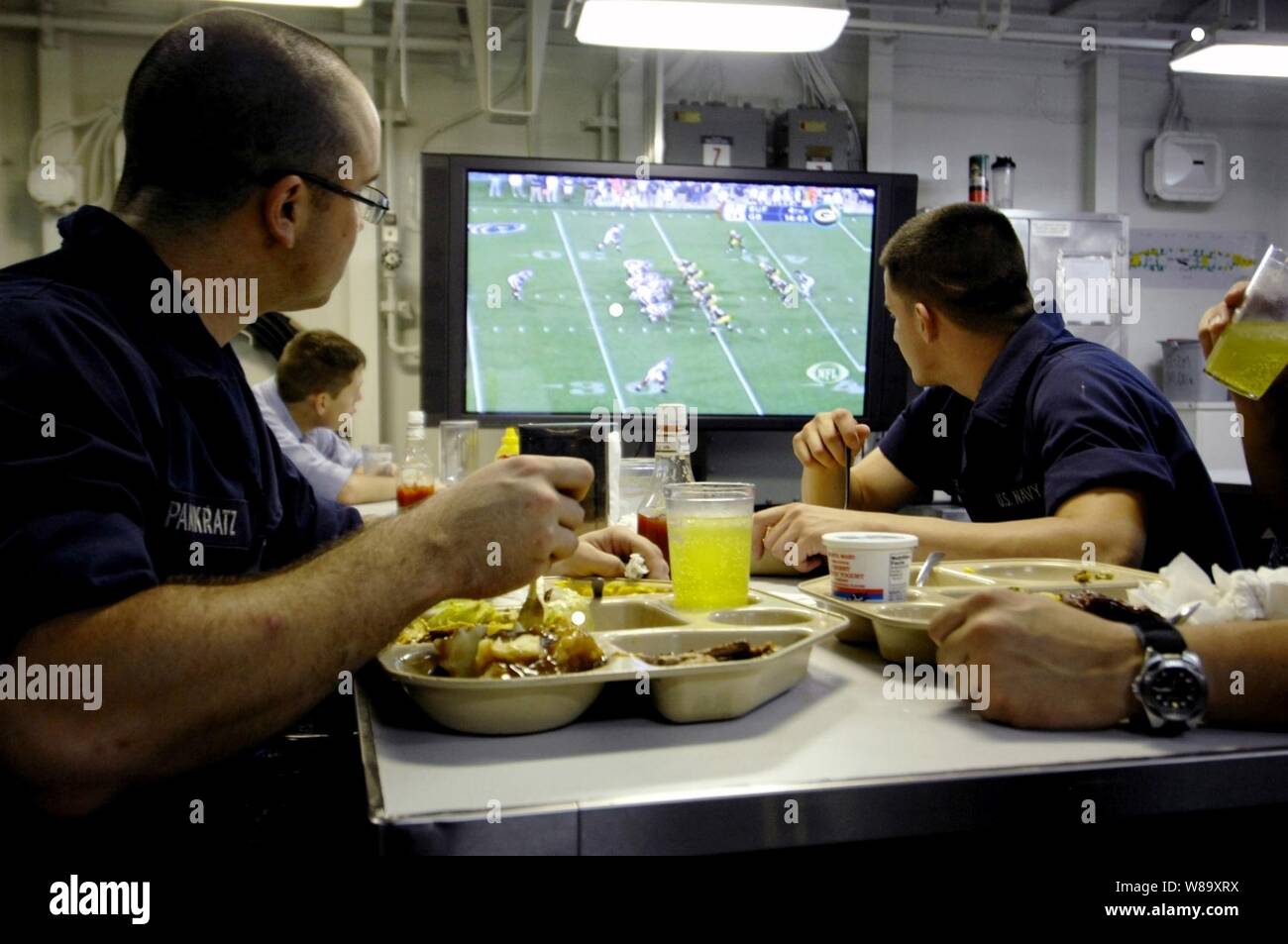 Les marins de la Marine américaine à bord du porte-avions USS Harry S. Truman (CVN 75) en cours dans l'océan Atlantique, regarder un match de football d'avant saison en mangeant dans le mess le 25 août, 2009. La NFL Network a récemment été ajouté à la gamme de la télévision par câble. Banque D'Images
