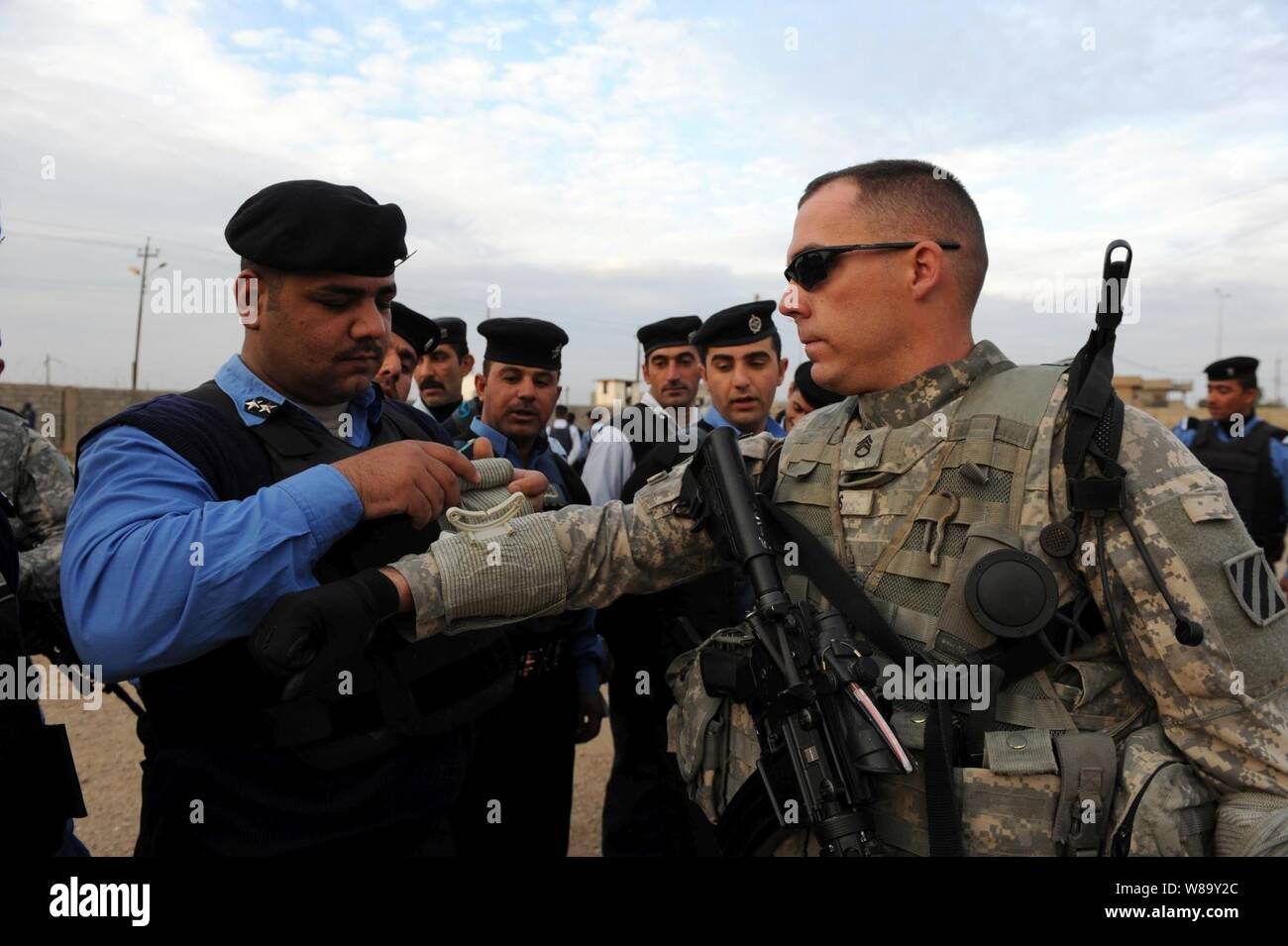 Le sergent de l'armée américaine. Michael Davis, le peloton de mortiers, siège de l'Administration centrale et compagnie, 1er Bataillon, 30e Régiment d'infanterie, 2e Brigade Combat Team, 3e Division d'infanterie, permet à un membre de l'unité d'intervention de la pratique des techniques de premiers secours sur son bras lors de la formation des premiers intervenants à la réponse qu'Unitís à Kirkouk, composé de l'Iraq, le 12 décembre 2009. Le bataillon travaille avec l'unité d'intervention d'urgence d'améliorer le professionnalisme et les capacités du personnel iraquien. Banque D'Images