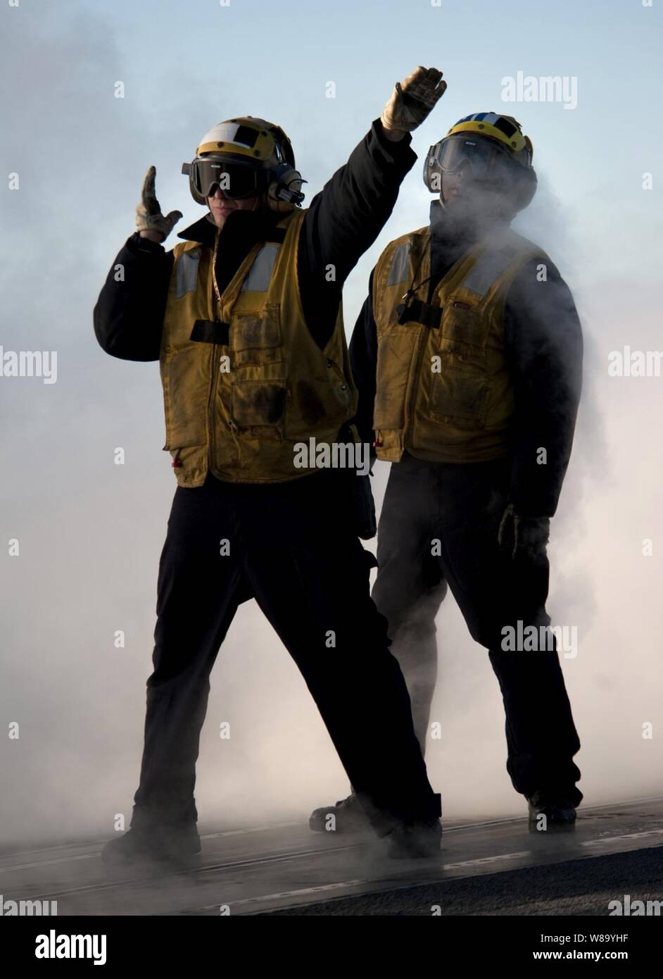 La Marine américaine Maître de 2e classe Jathan Lane (à gauche), directeur d'un avion affecté à V-1 de la Division du ministère de l'air à bord du porte-avions USS Carl Vinson (CVN 70), guides d'un aéronef sur une catapulte à vapeur en tant que maître de 3e classe David Myrtil observe en cours d'instruction actuellement en cours dans l'océan Pacifique le 1er décembre 2010. Le Carl Vinson et Carrier Air Wing 17 a effectué une formation de trois semaines de l'unité composite exercice avant un déploiement à l'ouest de l'océan Pacifique. Banque D'Images
