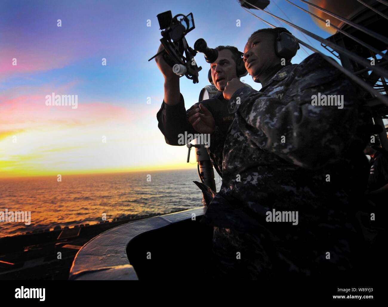 Le maître de Jonathan Myers commande enseigne Master Chief Beldo avril comment utiliser un sextant marin au cours d'une manifestation de la navigation astronomique à bord du porte-avions USS Carl Vinson (CVN 70) en cours dans l'océan Pacifique le 7 décembre 2010. Le Carl Vinson est sur une période de trois semaines de formation à l'exercice de l'unité composite sera suivie d'un déploiement à l'ouest de l'océan Pacifique. Banque D'Images