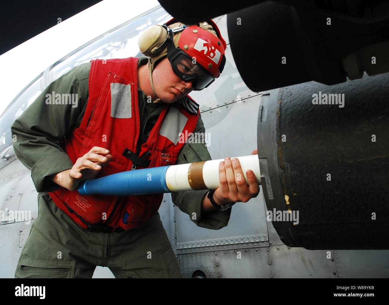 Le Corps des Marines des États-Unis. Jeremy charge un stand 2,75 pouces sur une fusée U.S. Marine Corps AH-1W Super Cobra hélicoptère pour un exercice de tir réel à bord du navire d'assaut amphibie USS Essex (DG 2) dans la mer des Philippines au cours de Keen Sword 2011 le 9 décembre 2010. Keen Sword est un accord bilatéral entre les États-Unis et le Japon en vue de l'exercice visant à renforcer les opérations militaires conjointes. Banque D'Images