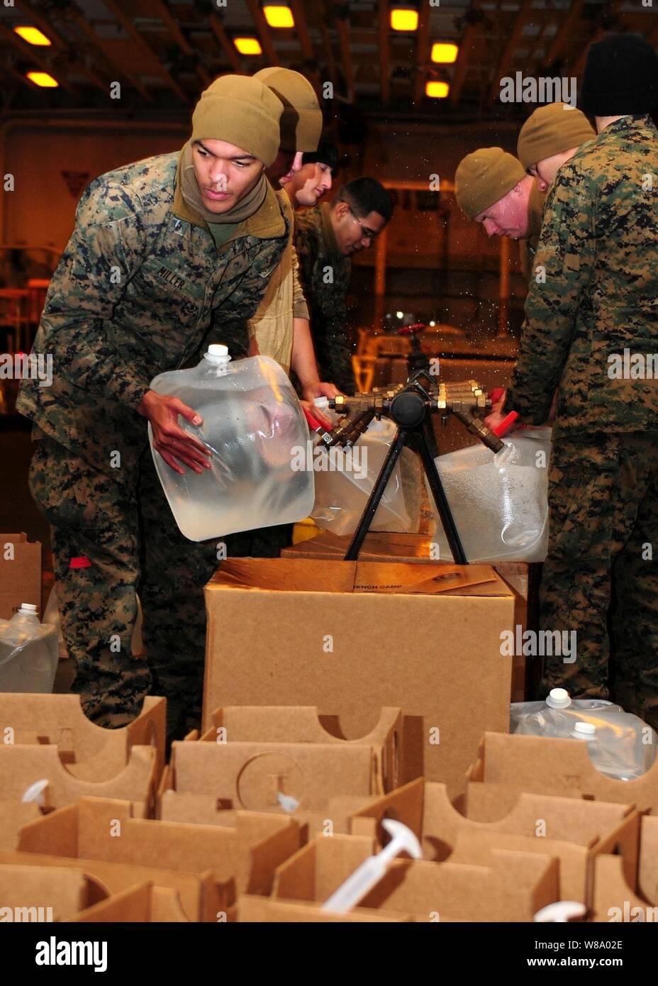 Les Marines américains affectés à la 31e Marine Expeditionary Unit remplir des récipients en plastique avec de l'eau potable dans la zone du navire d'assaut amphibie USS Essex (DG 2) dans l'océan Pacifique le 25 mars 2011. L'eau a été transporté à divers endroits au Japon comme un cadre de l'opération Tomodachi. L'Essex et le quai des navires de débarquement USS Harpers Ferry (LSD 49) et USS Germantown (LSD 42), ainsi que la 31e unité expéditionnaire de Marines embarqués étaient en exploitation au large de la côte de Hachinohe dans nord-est du Japon. Banque D'Images