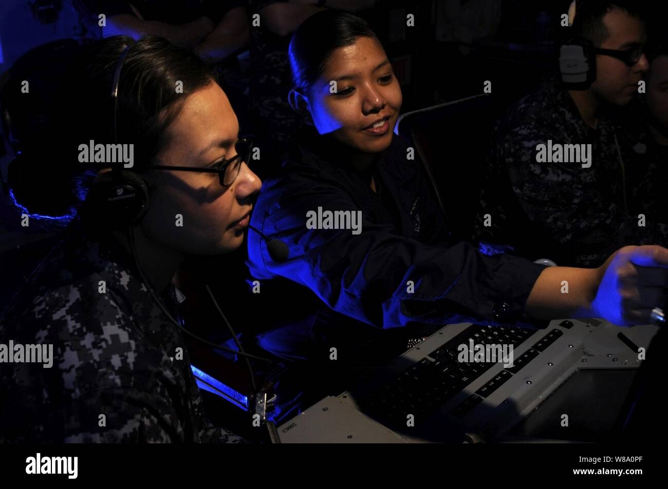 La Marine américaine Maître de 2e classe Katherine Newquist (à gauche) et l'Apprenti matelot Leizle Aspili analyser les fréquences radar dans le module de guerre électronique à bord du porte-avions USS Carl Vinson (CVN 70) dans la mer d'Oman le 20 janvier, 2012. Le Carl Vinson et Carrier Air Wing 17 sont déployés dans le 5e Flotte des États-Unis zone de responsabilité. Banque D'Images