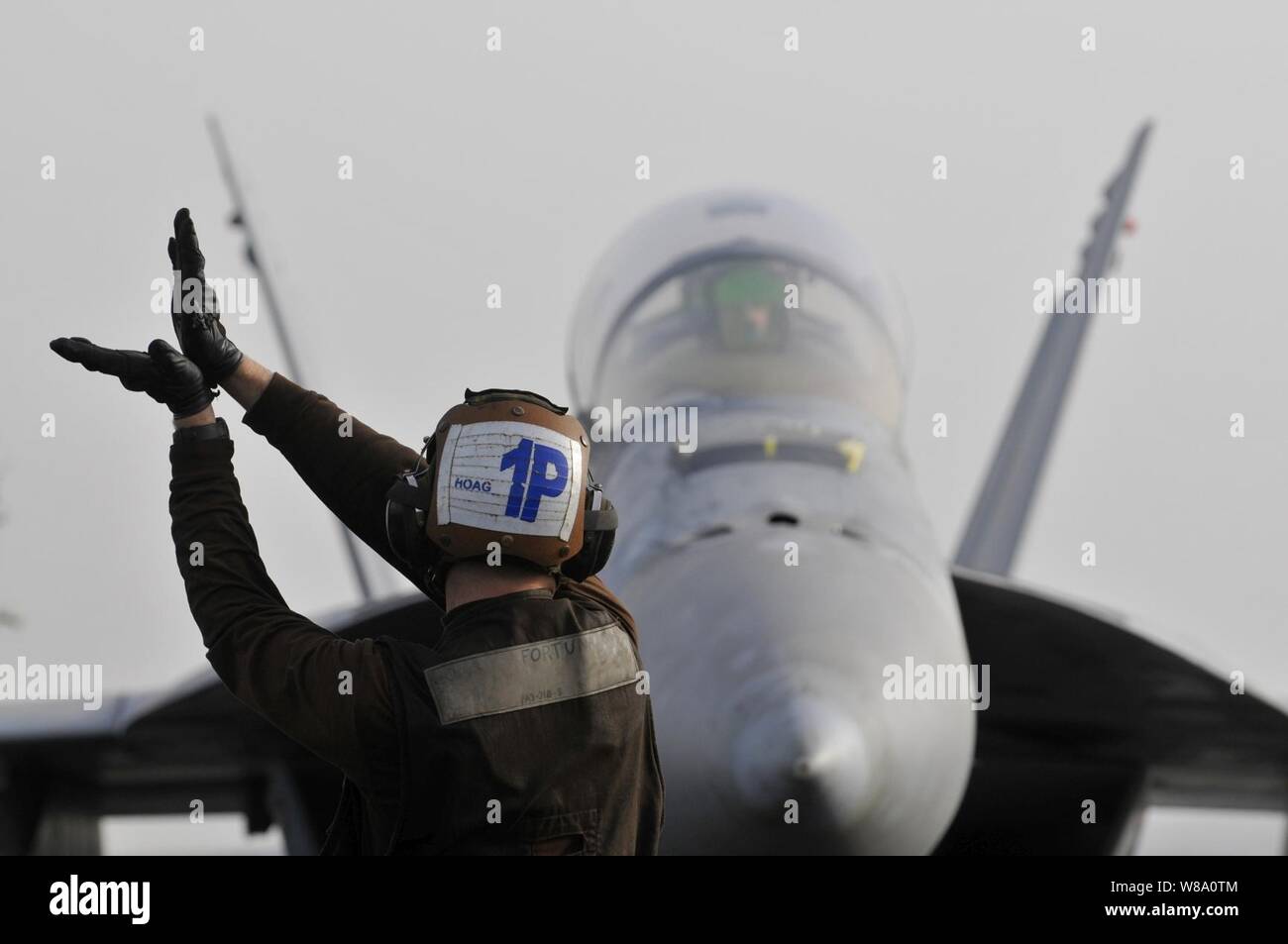 L'aviateur de la Marine américaine Hoag, Mackenzie attribué à Strike Fighter Squadron 22, signaux pour le pilote d'un F/A-18F Super Hornet à bord du porte-avions USS Carl Vinson (CVN 70) pendant qu'ils sont en cours dans le golfe Persique le 5 mars 2012. Le Carl Vinson et Carrier Air Wing 17 sont déployés dans le 5e Flotte des États-Unis zone de responsabilité. Banque D'Images