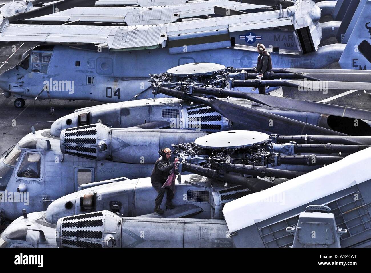 Les Marines américains d'effectuer des opérations de maintenance sur les deux CH-53E Sea Stallion Helicopters à bord du navire d'assaut amphibie USS Iwo Jima en cours dans l'Océan Atlantique le 4 avril 2012. Les marines sont affectés à l'escadron 261 à rotors basculants moyen maritime. L'Iwo Jima est déployée dans le cadre de l'Iwo Jima Groupe amphibie à l'appui d'opérations de sécurité maritime et les efforts de coopération en matière de sécurité dans le théâtre aux États-Unis la 5ème et la 6ème flotte domaines de responsabilité. Banque D'Images