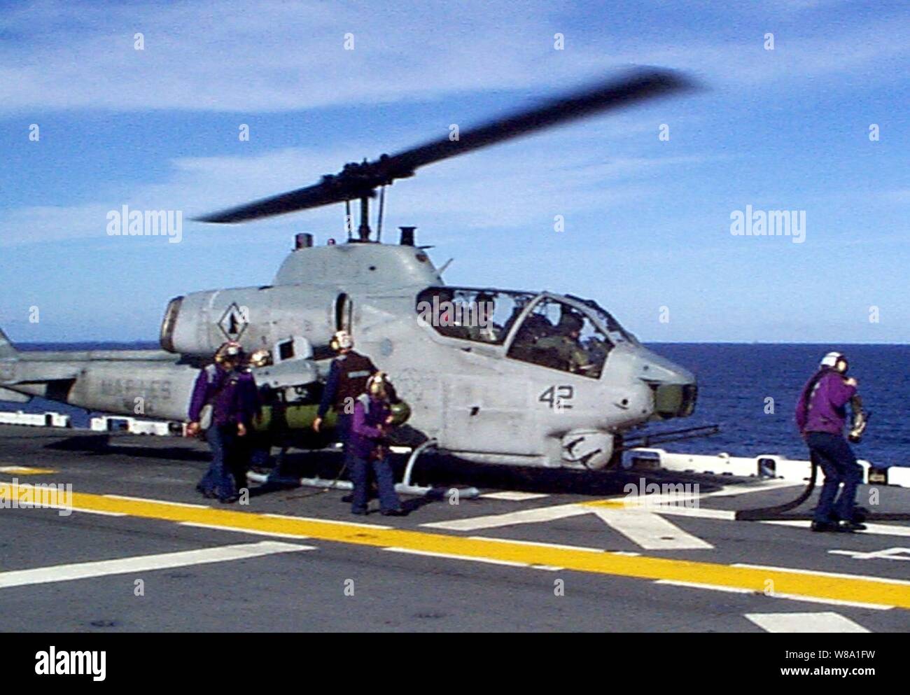 Les membres d'équipage à bord du navire d'assaut amphibie USS Wasp LHD (1) SEX faites le plein d'un Corps des Marines américains AH-1W Super Cobra sur le 17 janvier 1998, au cours d'exercice d'une force opérationnelle 98 1. Plus de 30 000 militaires américains participent à l'exercice qui est de tester les forces interarmées sur leur capacité à se déployer rapidement et de mener des opérations conjointes au cours d'une crise. Toutes les branches des forces armées sont la formation side-by-side en utilisant les dernières avancées technologiques dans le domaine de la simulation d'un environnement à haut risque qui implique l'air, les opérations navales et terrestres. Le Super Hélicoptère Cobra est attaché à Banque D'Images